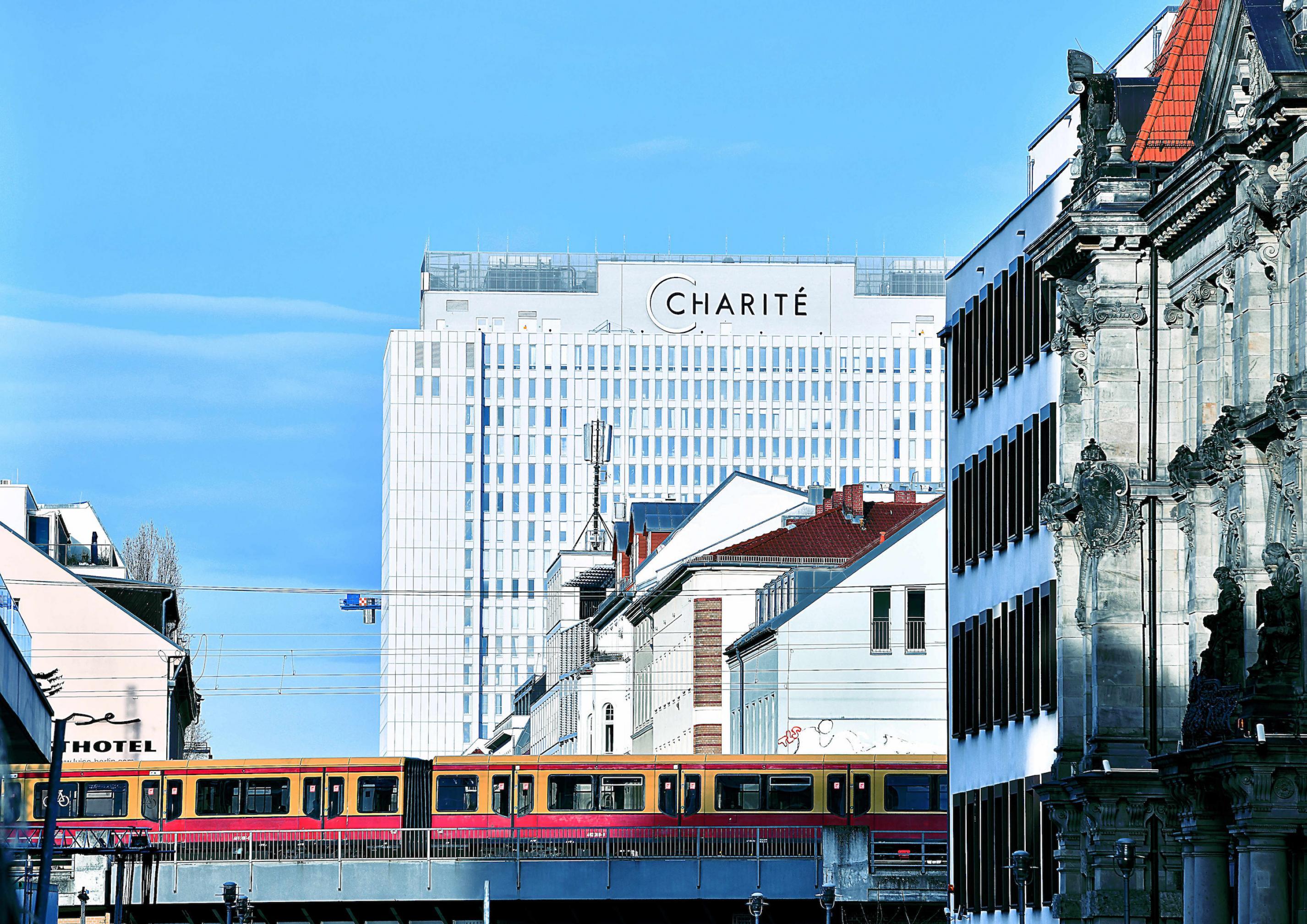 Das Hochhaus der Charité im Berliner Zentrum, im Vordergrund eine S-Bahn.