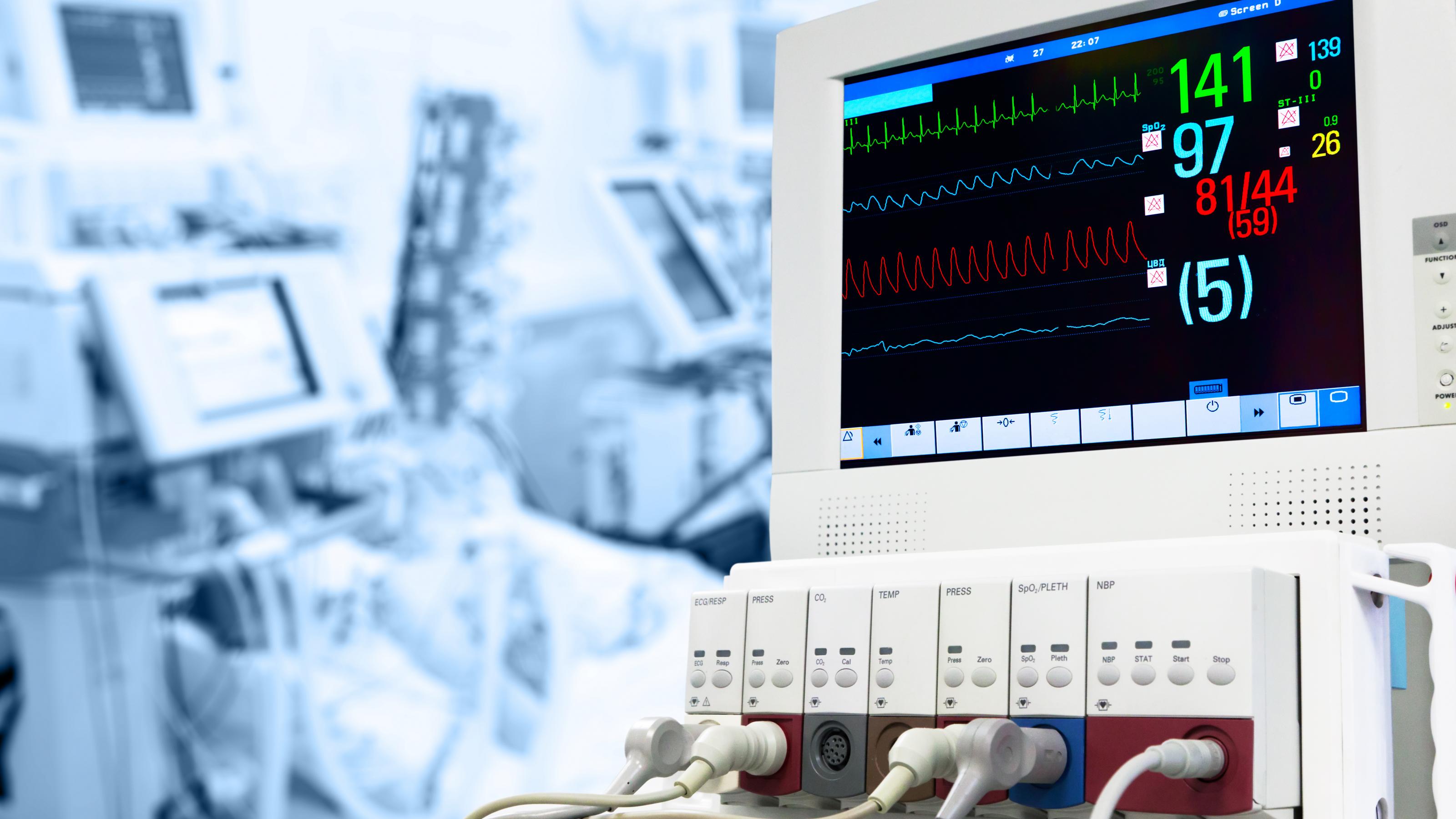 Das Foto zeigt einen Monitor, der Angaben zur Herz-Kreislauf-Funktion von Patientinnen und Patienten auf einer Intensivstation anzeigt.