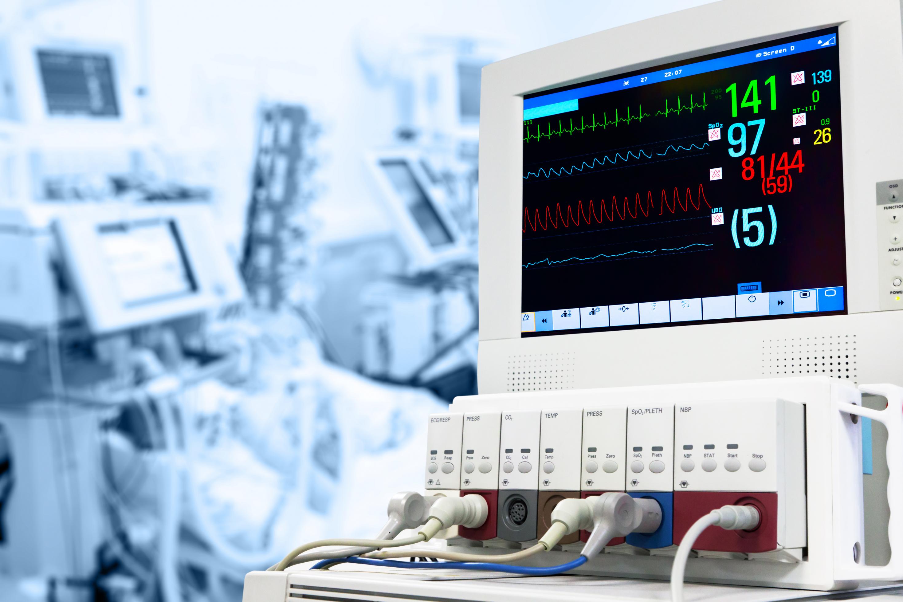 Das Foto zeigt einen Monitor, der Angaben zur Herz-Kreislauf-Funktion von Patientinnen und Patienten auf einer Intensivstation anzeigt.