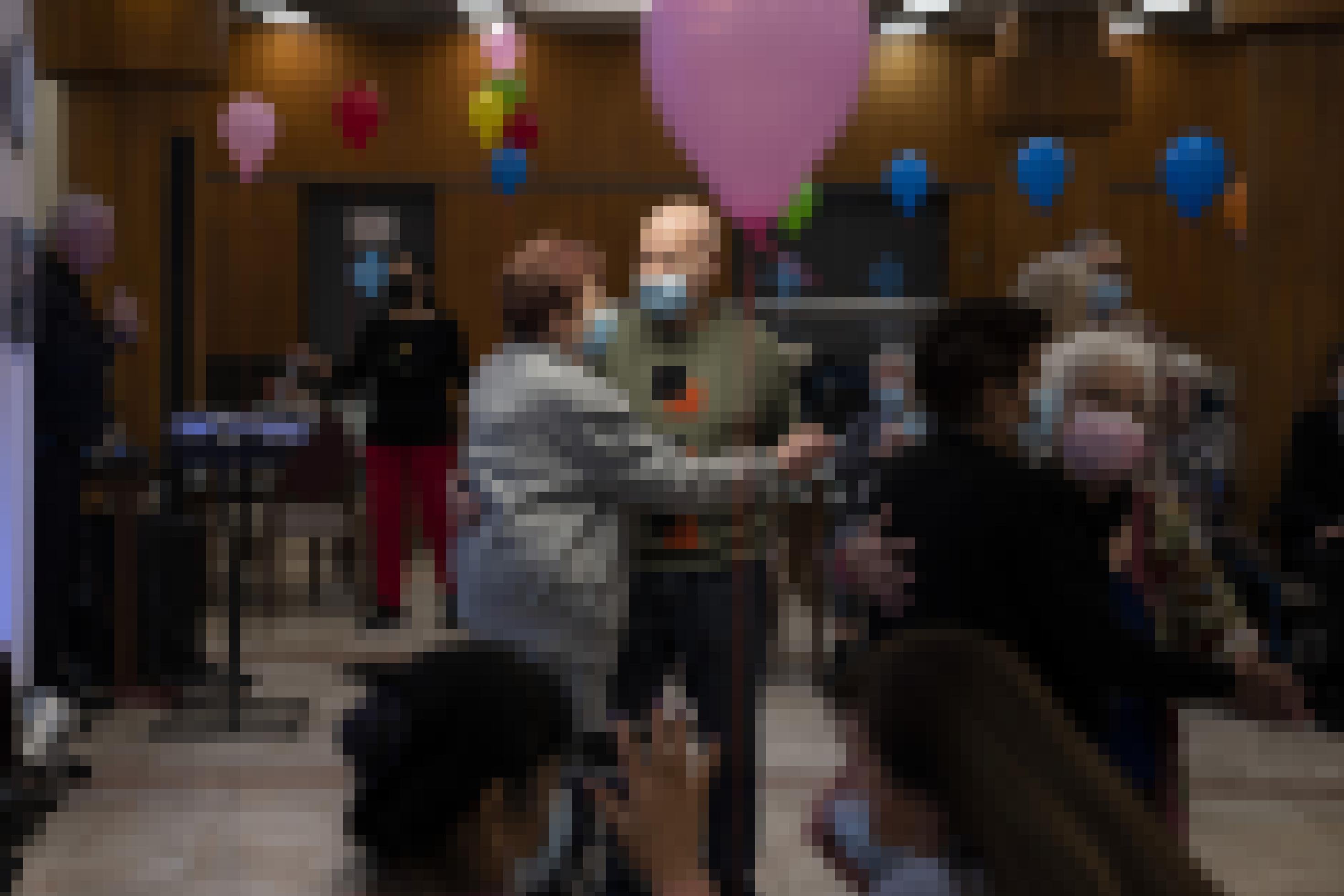 Ältere Menschen tanzen in einem Saal mit Luftballons, im Zentrum ein Mann und eine Frau.