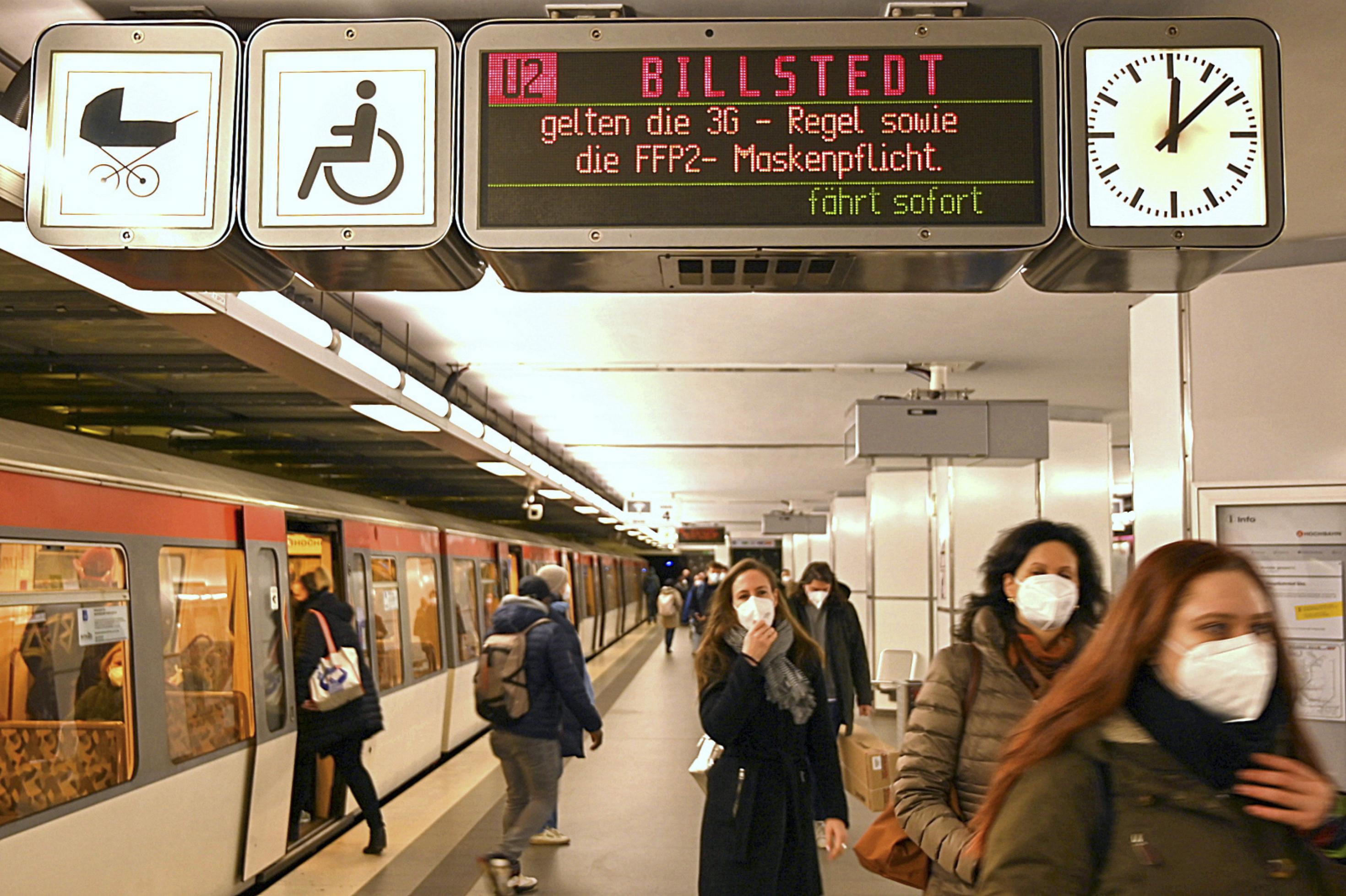 Szene am U-Bahnsteig in Hamburg. Frauen steigen aus einer U-Bahn aus, sie tragen Masken.
