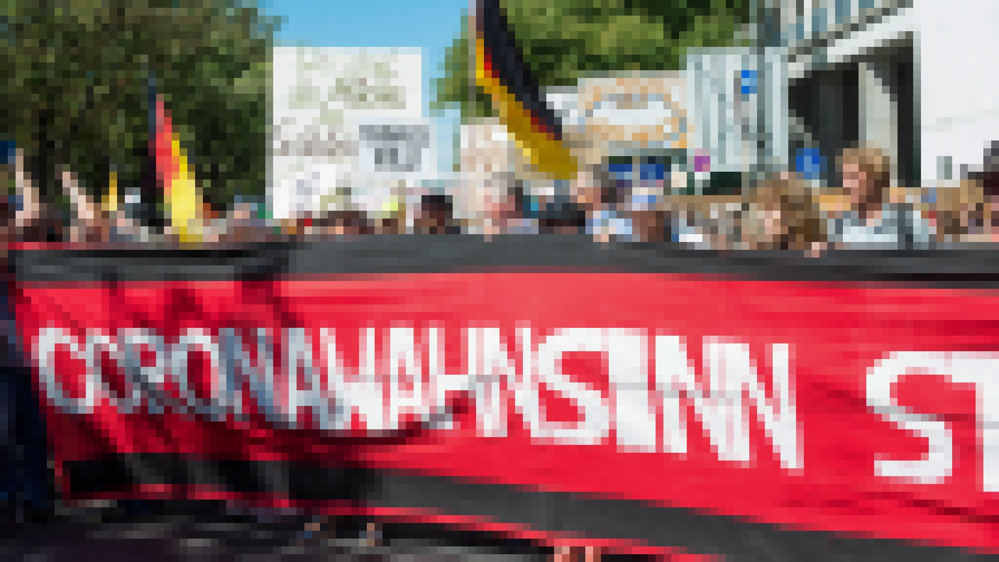 Demonstranten in Berlin halten ein Banner mit der Aufschrift „Coronawahnsinn“. Dahinter weitere mit Schildern und Deutschlandfahnen.