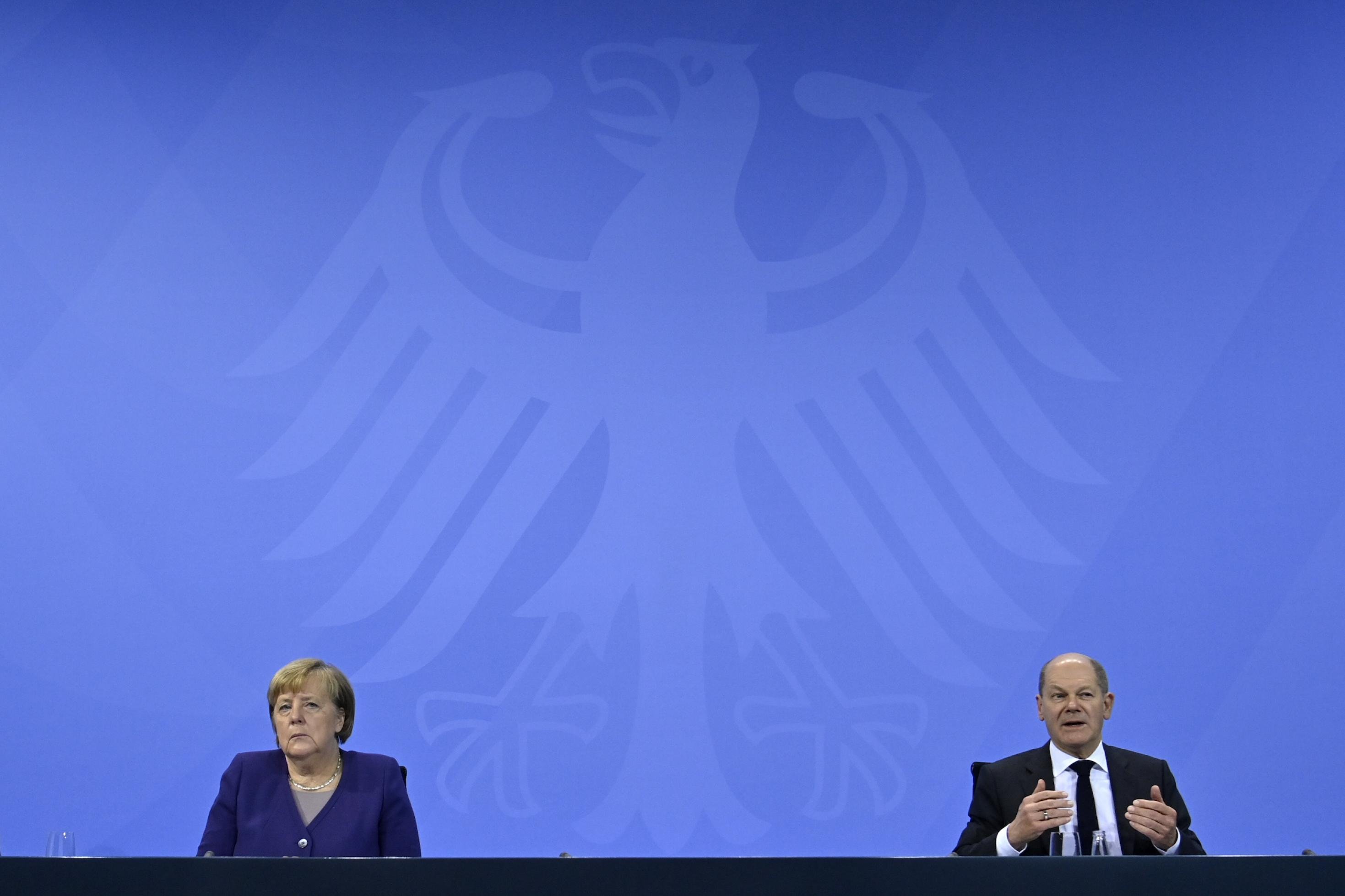Bundeskanzlerin Angela Merkel (CDU) und Olaf Scholz (SPD) vor einem großen Bundesadler