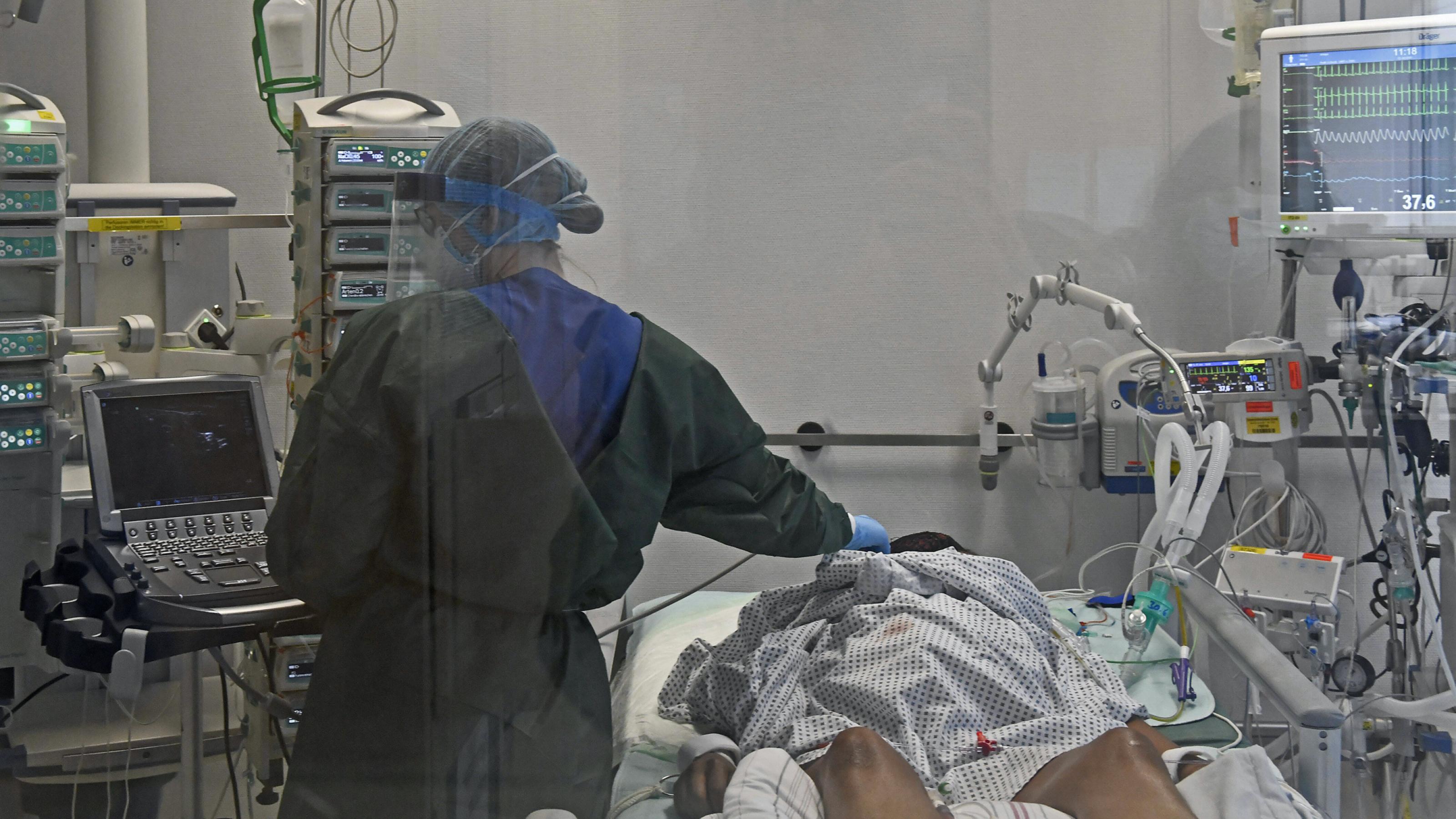 Blick in die Intensivstation der Universitätsklinik Essen mit Covid-19-Beatmungsgerät. Ärzte tragen Maske und behandeln einen Corona-Patienten.