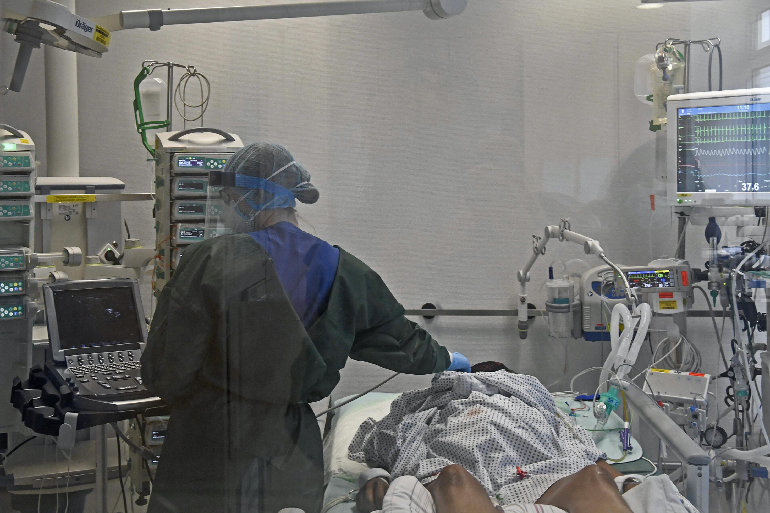 Blick in die Intensivstation der Universitätsklinik Essen mit Covid-19-Beatmungsgerät. Ärzte tragen Maske und behandeln einen Corona-Patienten.