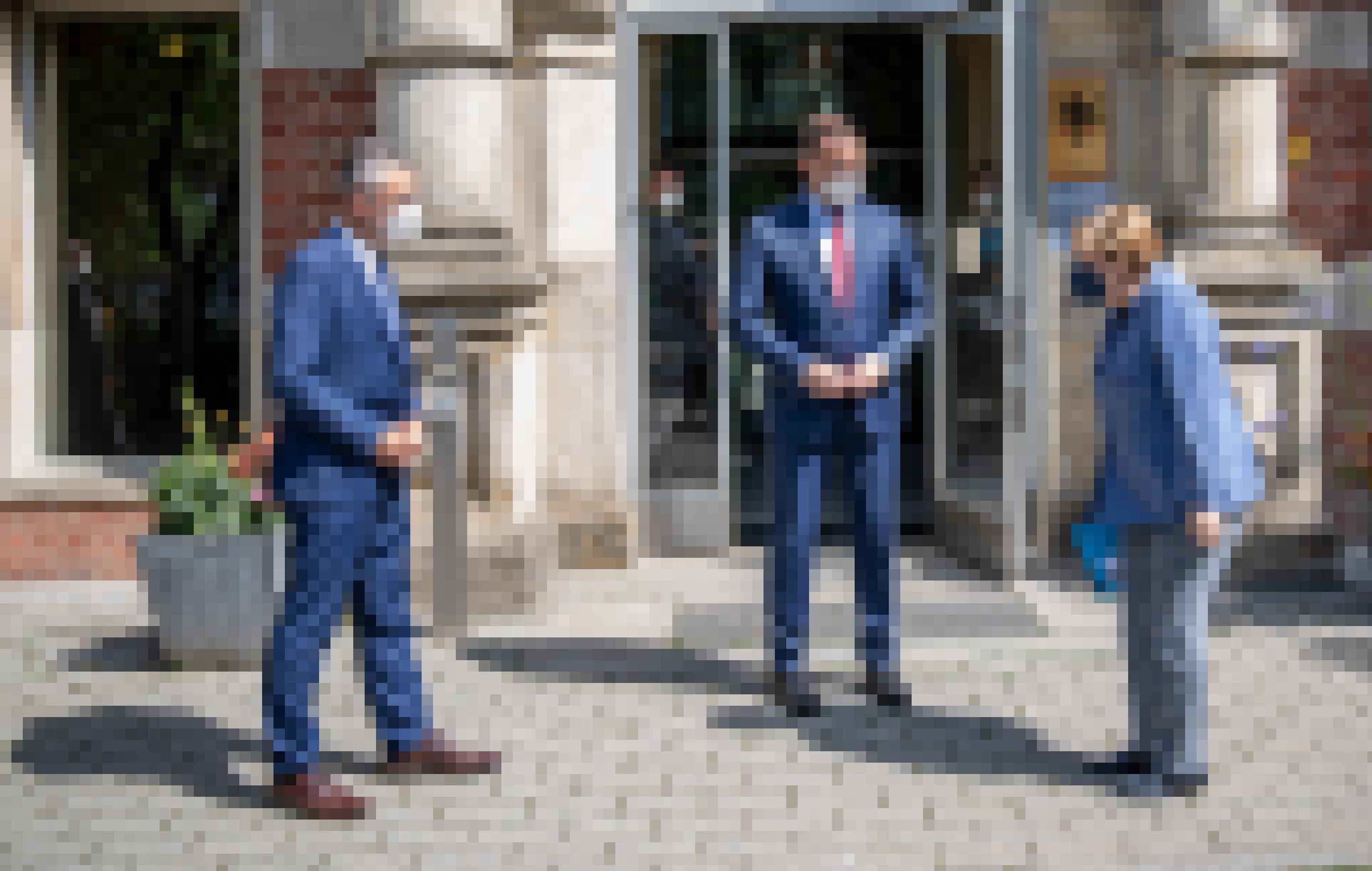 Bundeskanzlerin Angela Merkel wird neben Jens Spahn von Lothar Wieler, Präsident des Robert Koch Instituts (RKI), vor dem Eingang des RKI begrüsst.
