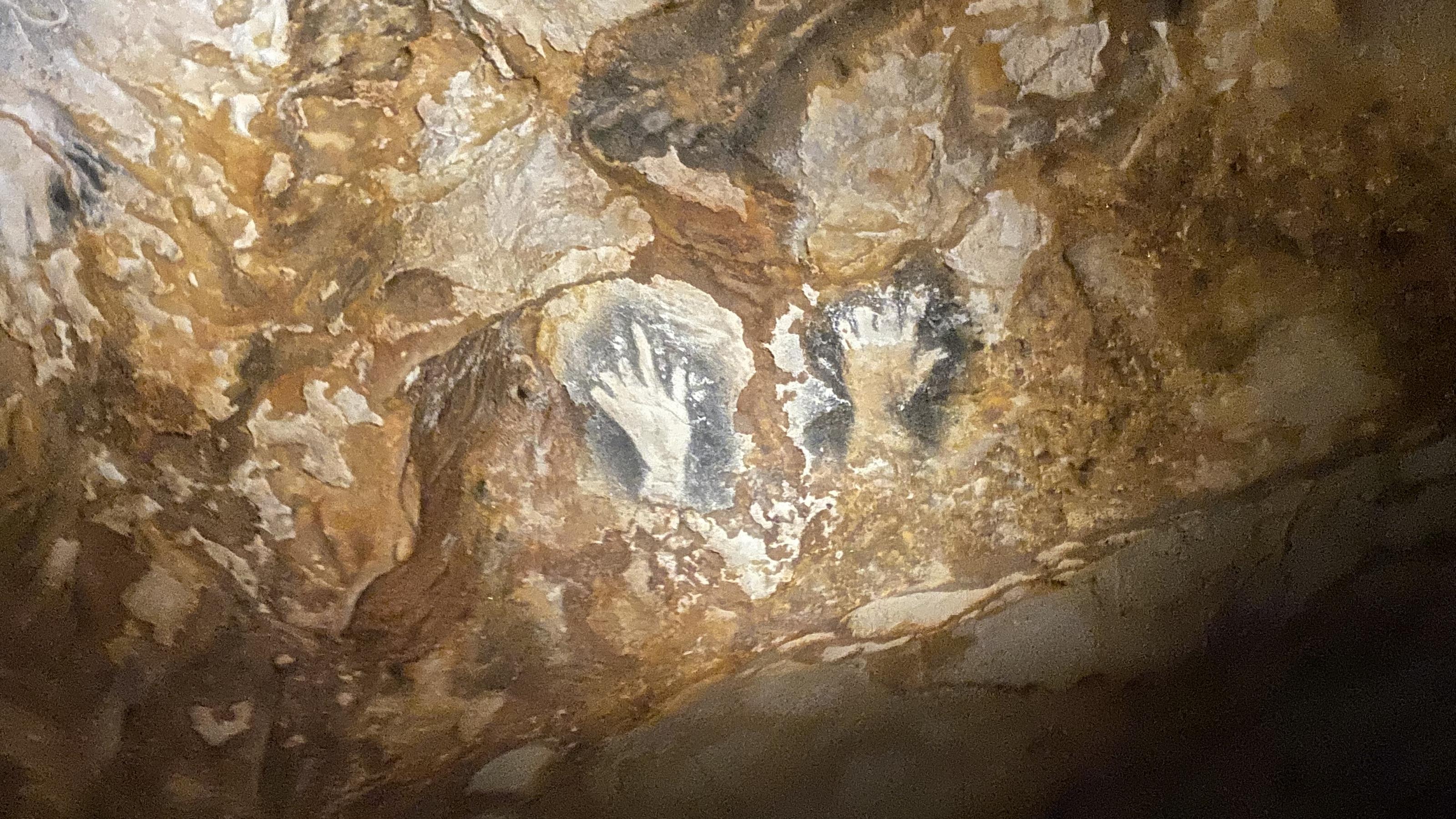 Die Zeichnung menschliche Hände an der Höhlenwand.
