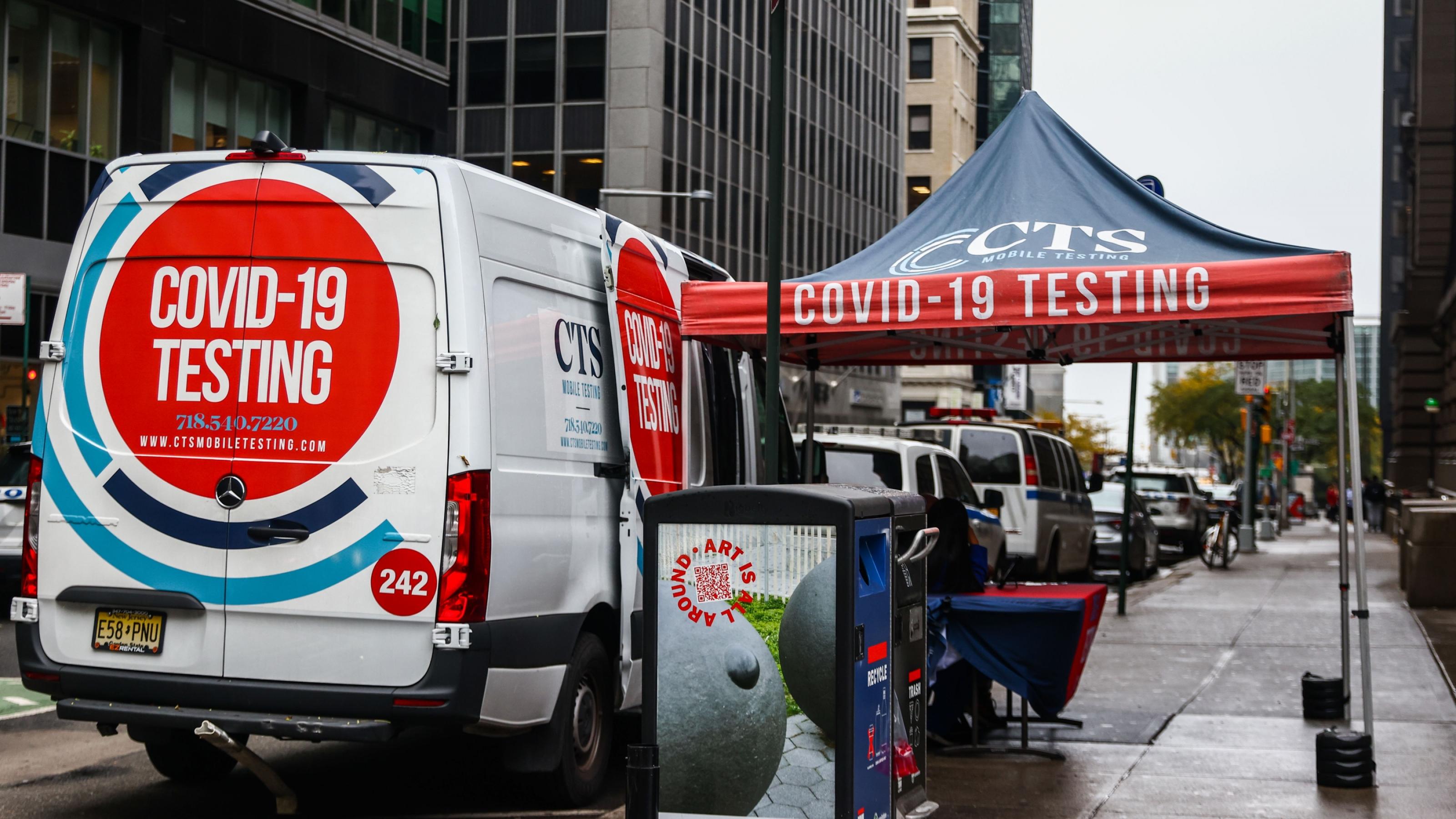Ein Lieferwagen auf einer Straße in New York dient als mobiles Testzentrum. Daneben ist ein kleines Zelt als Regenschutz aufgebaut. Es ist niemand dort.