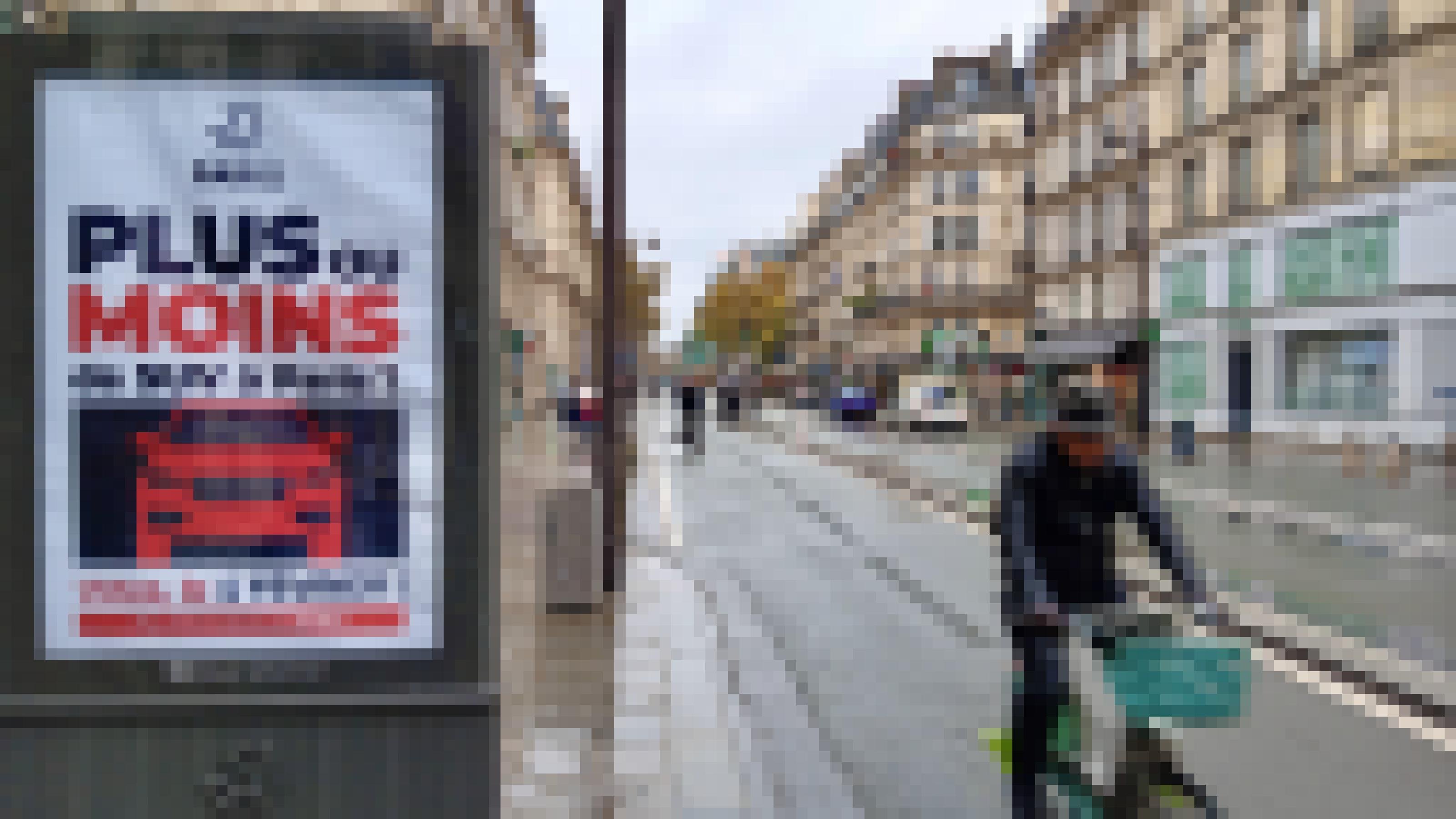 Ein Radfahrer fährt in Paris an einem Plakat vorbei
