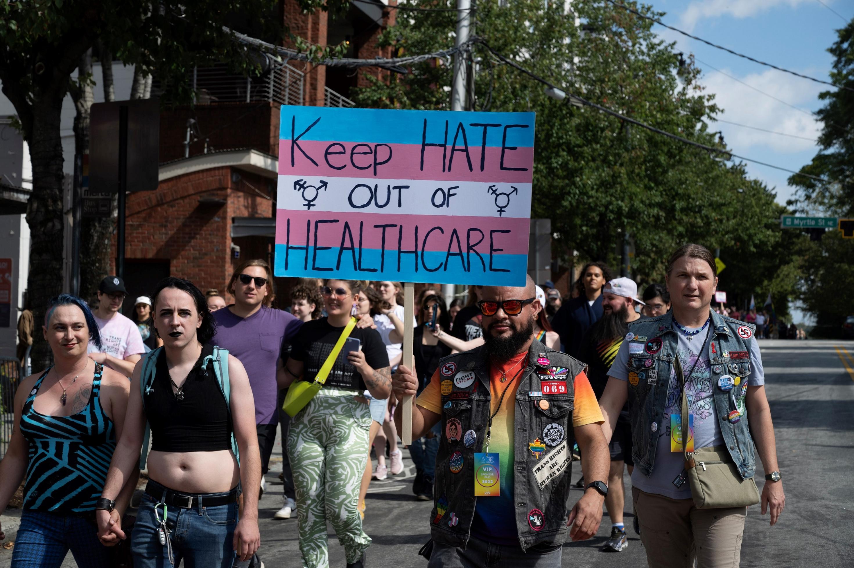 Eine Gruppe von Menschen auf einer Demonstration. Einer trägt ein Schild mit folgendem Text: „Keep health out of healthcare.“