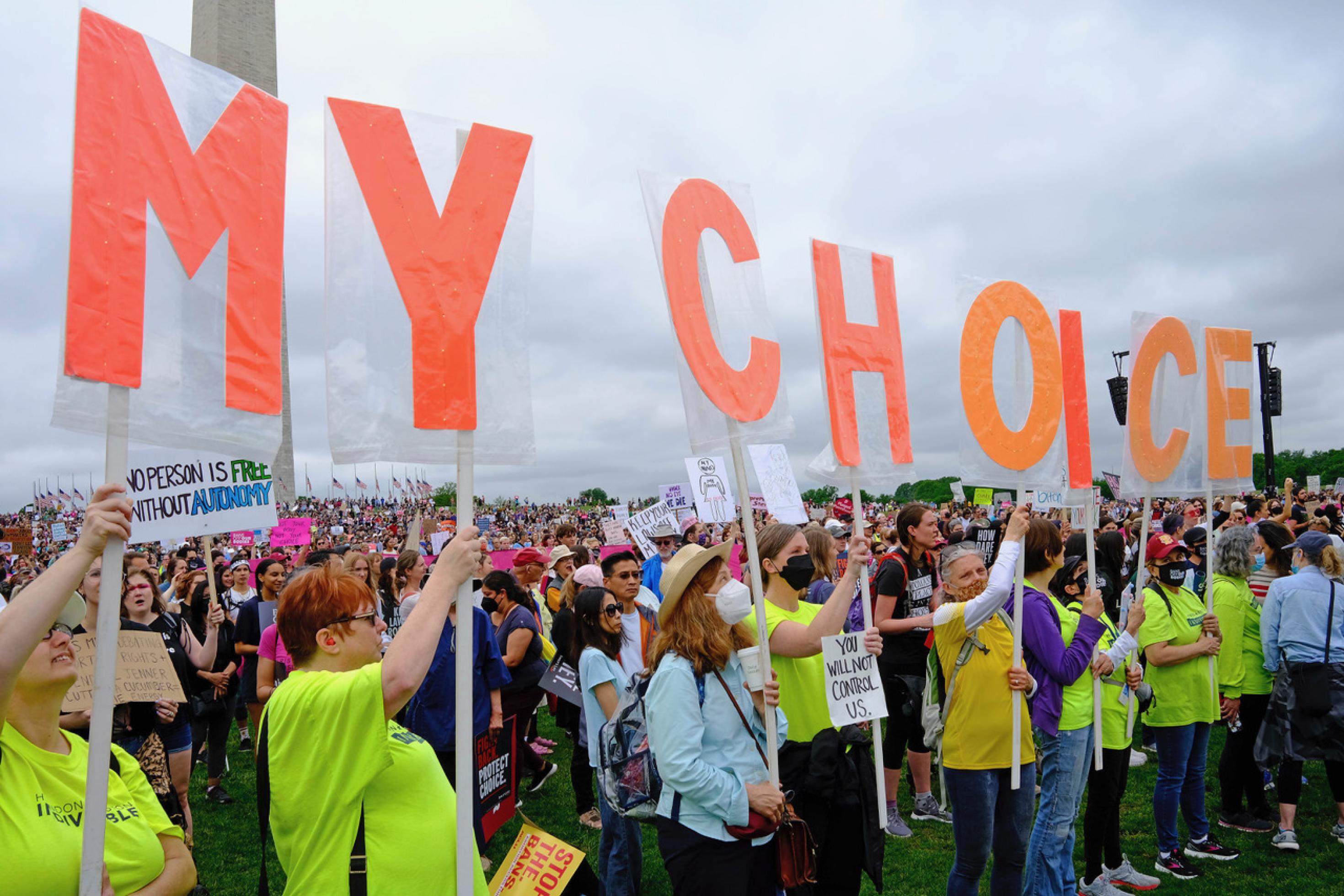 Demonstrierende halten Plakate mit Buchstaben in die Höhe, die zusammen den Satz „My Choice“ ergeben.