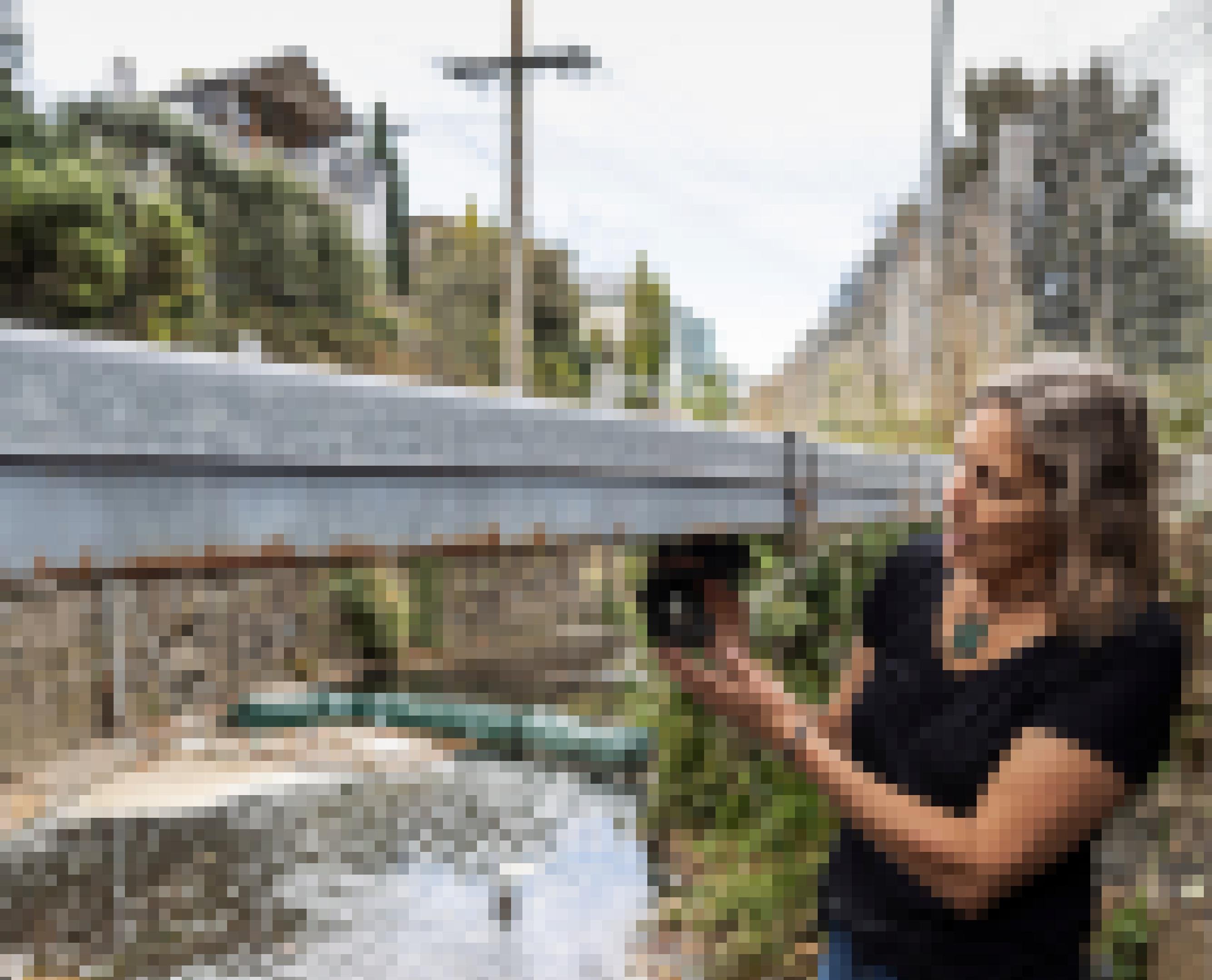 Die Wissenschaftlerin Denise Hardesty steht unter einer Brücke in  Tasmanien und kontrolliert eine Kamera, die Daten über Plastikmüll liefert.