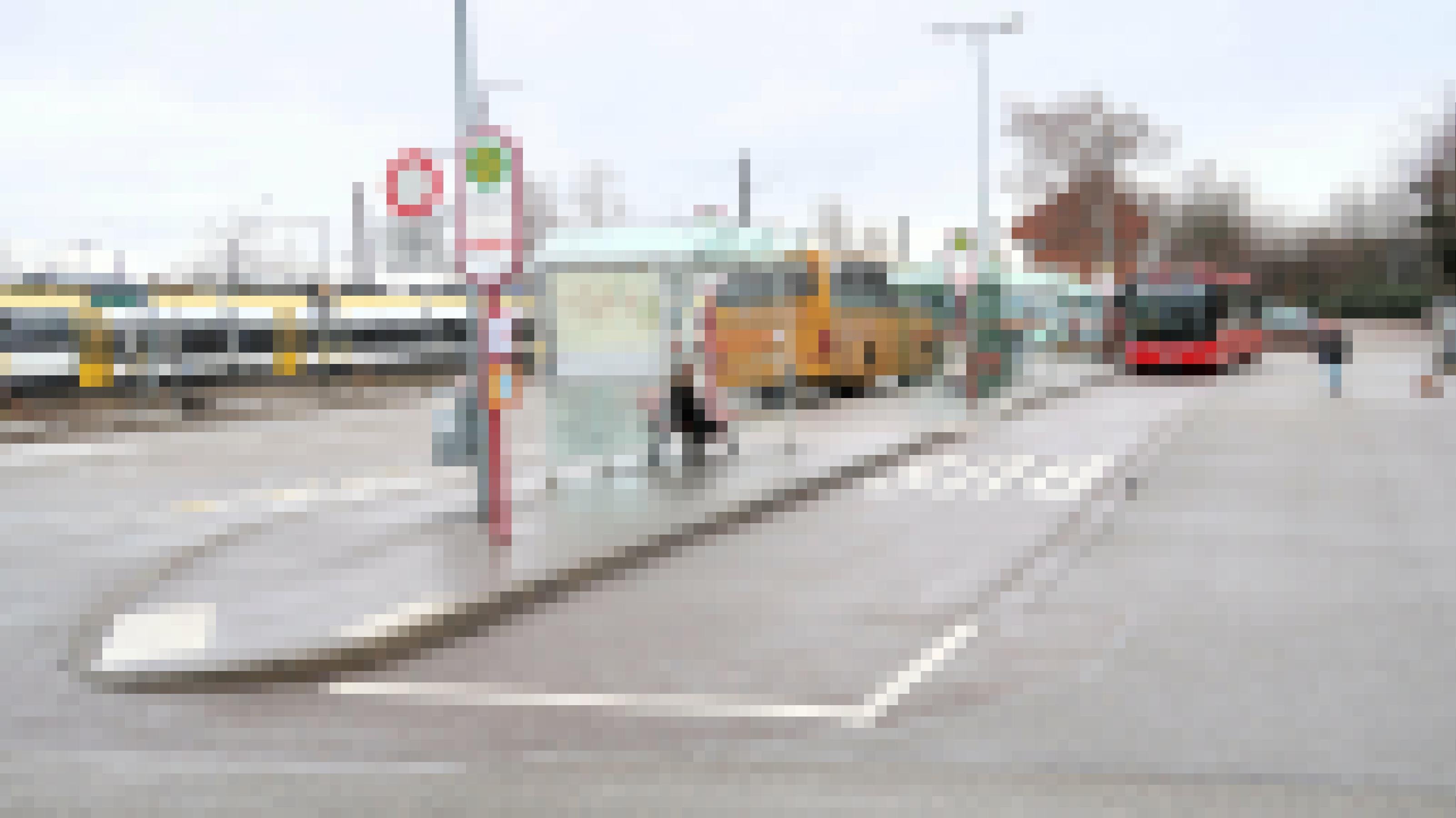Busbahnhof in Denzlingen mit Bussen und Zügen. Eine Frau führt ihren Hund aus.