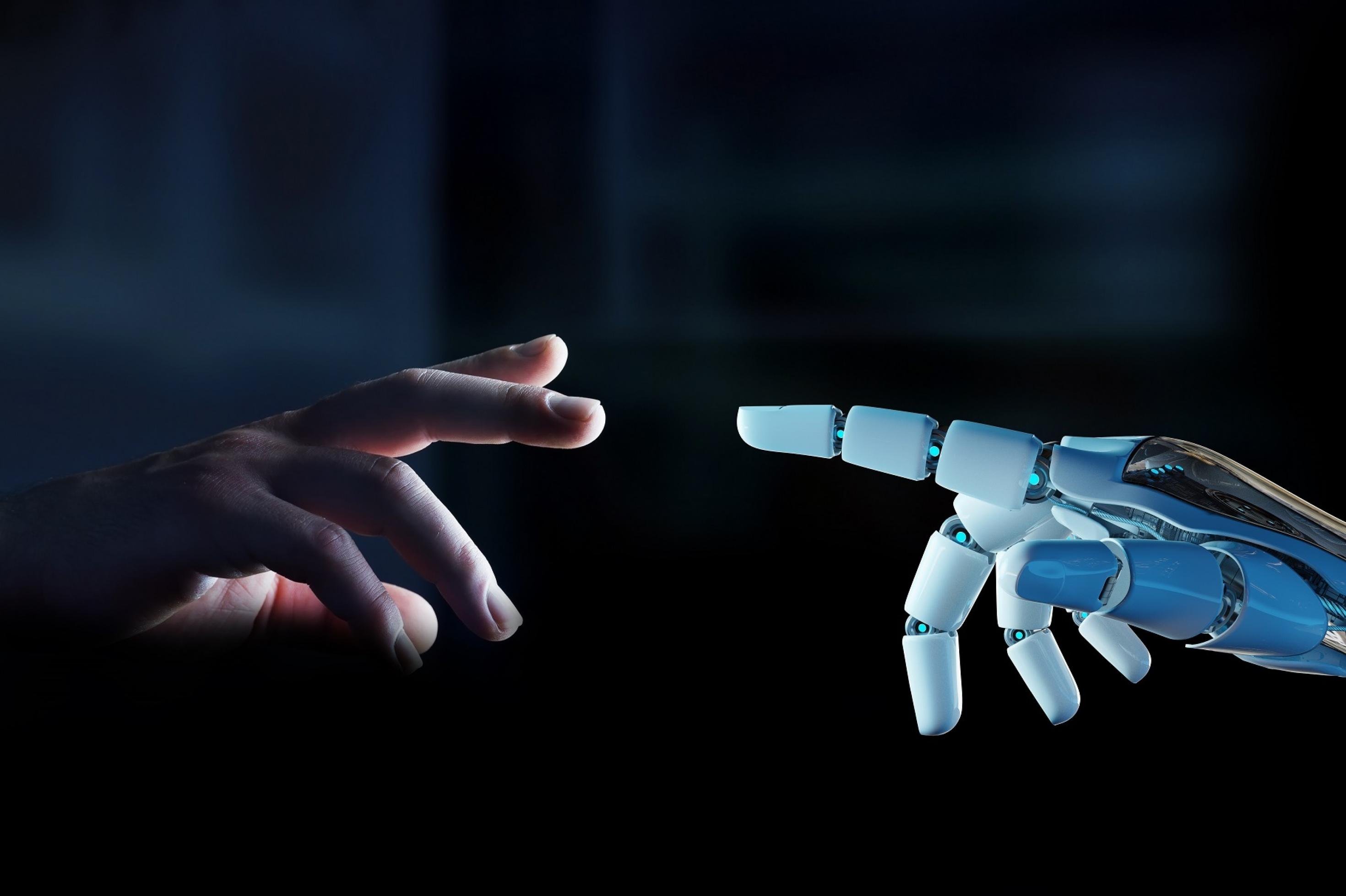 Ein weißer Roboterfinger ist kurz davor, einen menschlichen Finger zu berühren, der sich ihm vor dunklem Hintergrund entgegenstreckt.