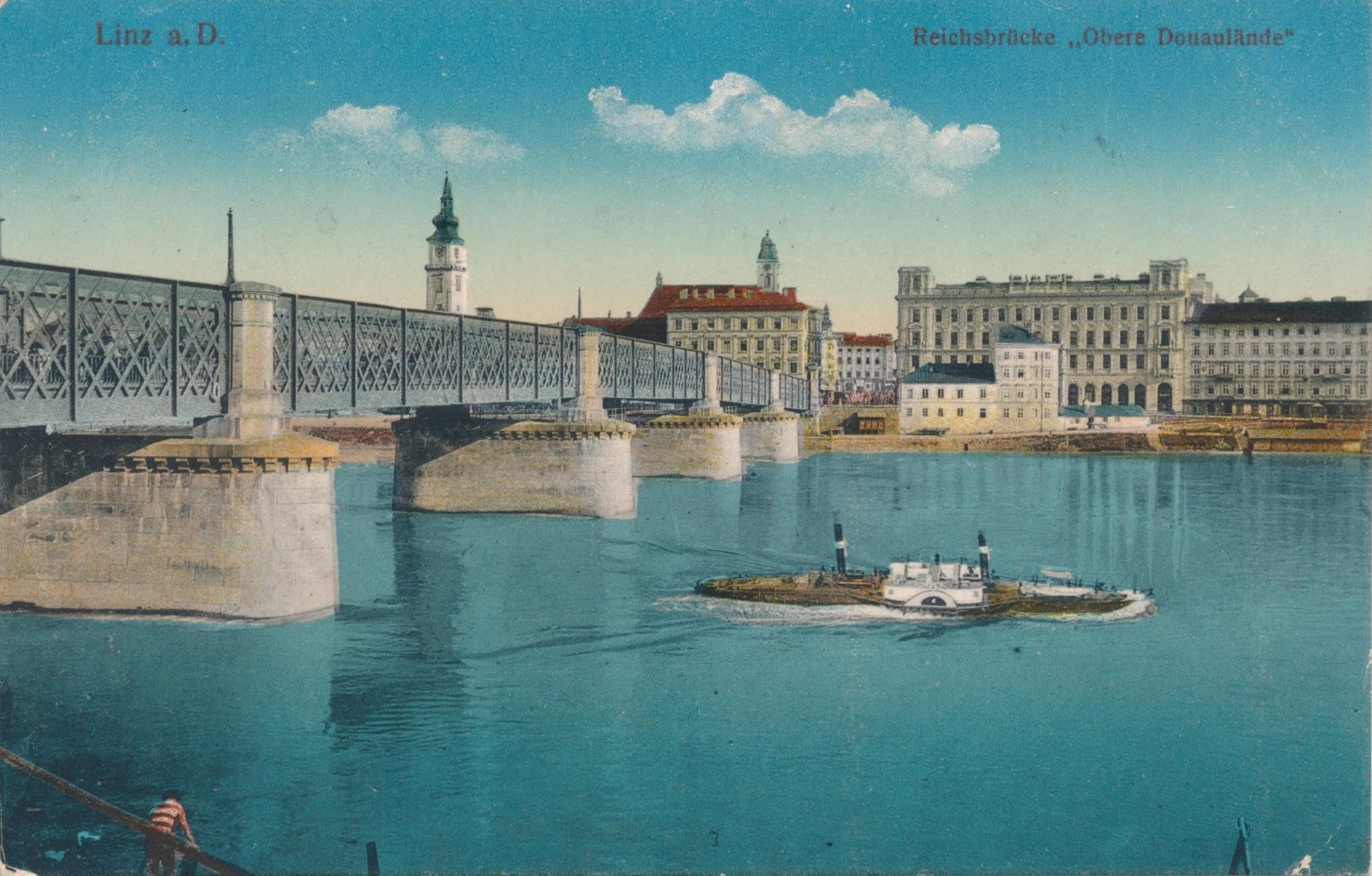 Brücke, Häuser, türkisblauer Fluss und Schiff.