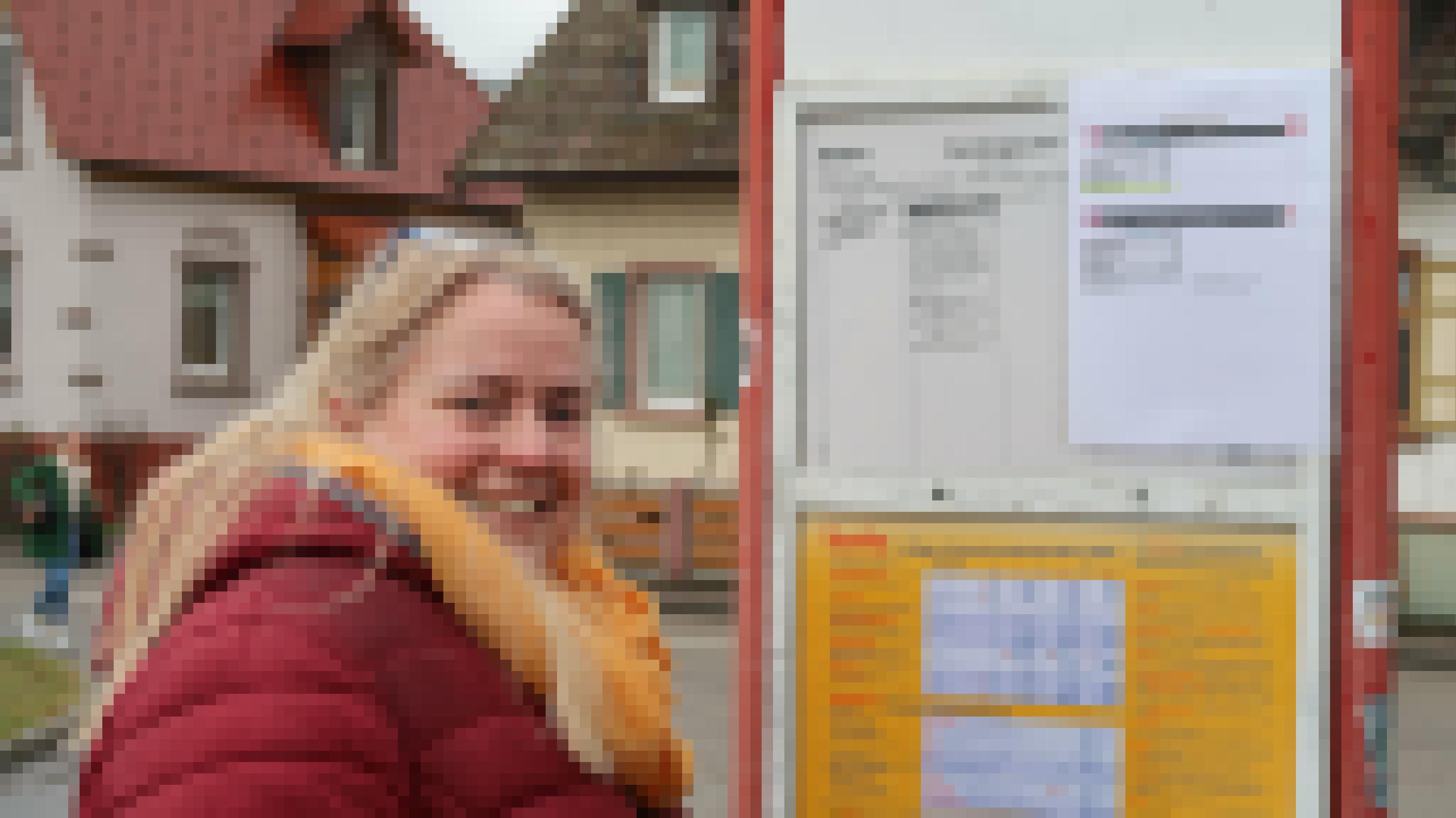 Eine Frau steht vor dem Fahrplan einer Bushaltestelle.
