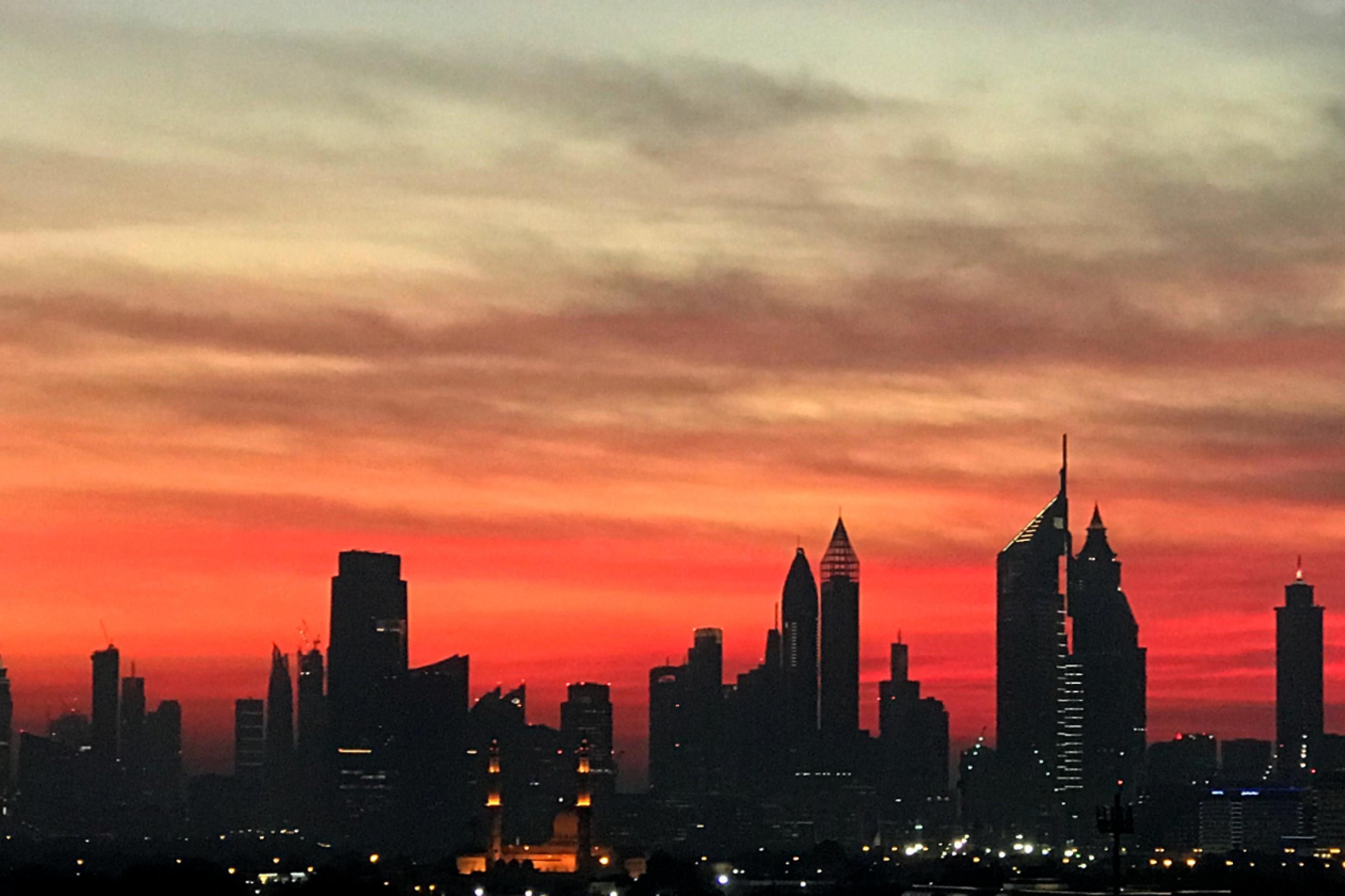 Die Skyline von Dubai mit etlichen Wolkenkratzern und rotem Abendhimmel