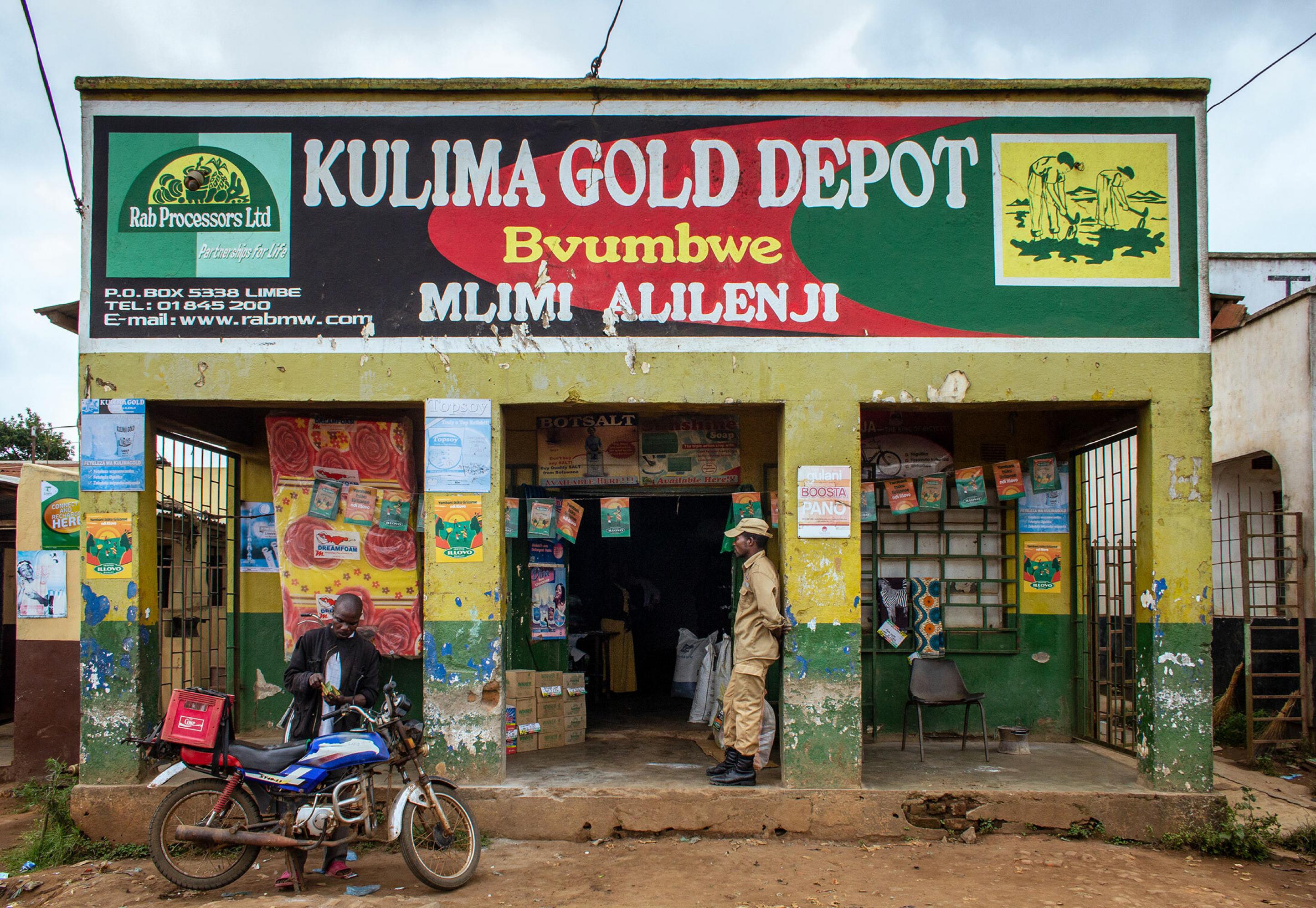 Ladenfassade eines Landhandels in Malawi. Im Eingang stehen Säcke mit Dünger und andere Produkte.