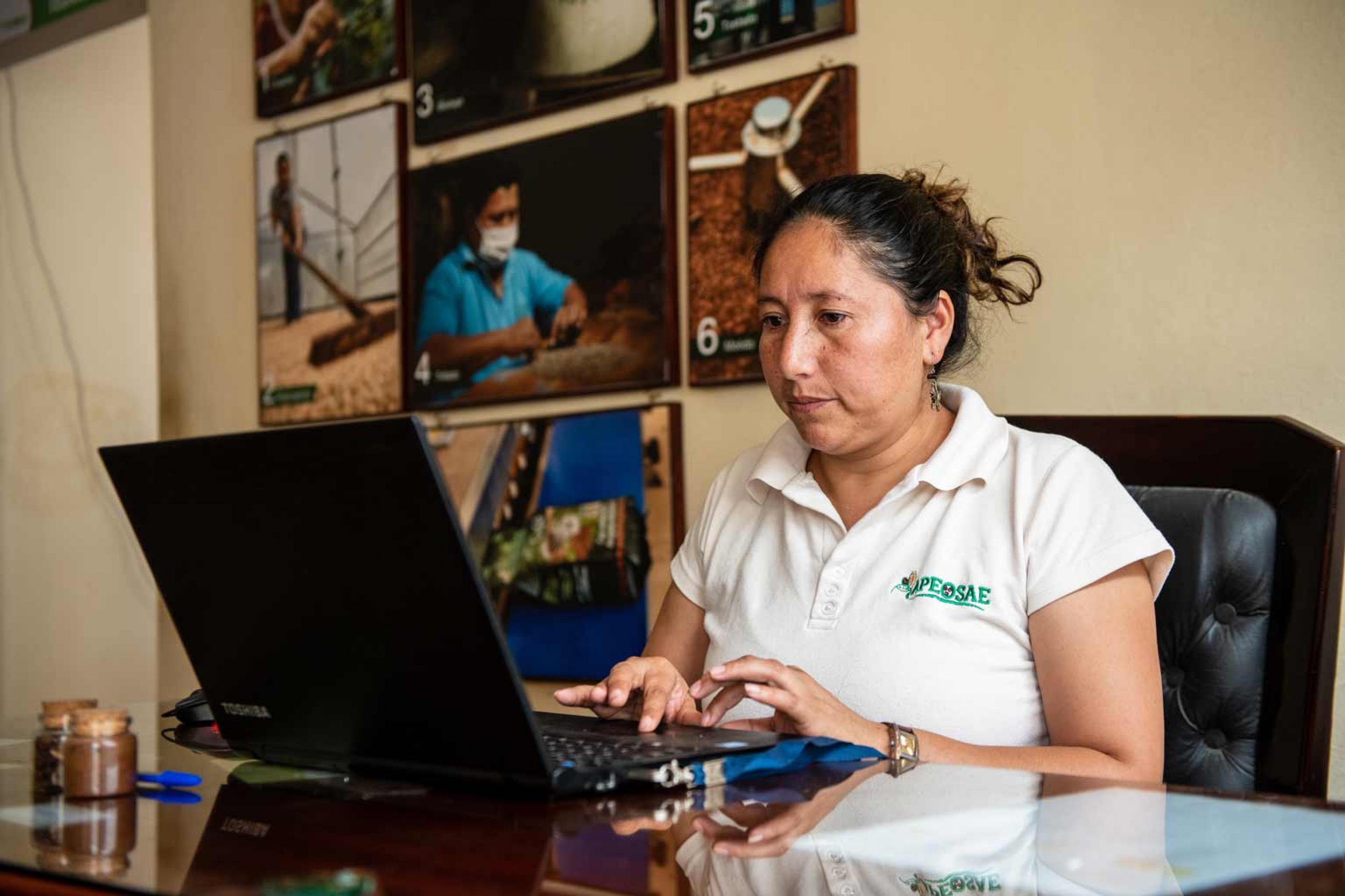 Nora Ramó arbeitet in ihrem Büro am Computer, Panguintza/Ecuador