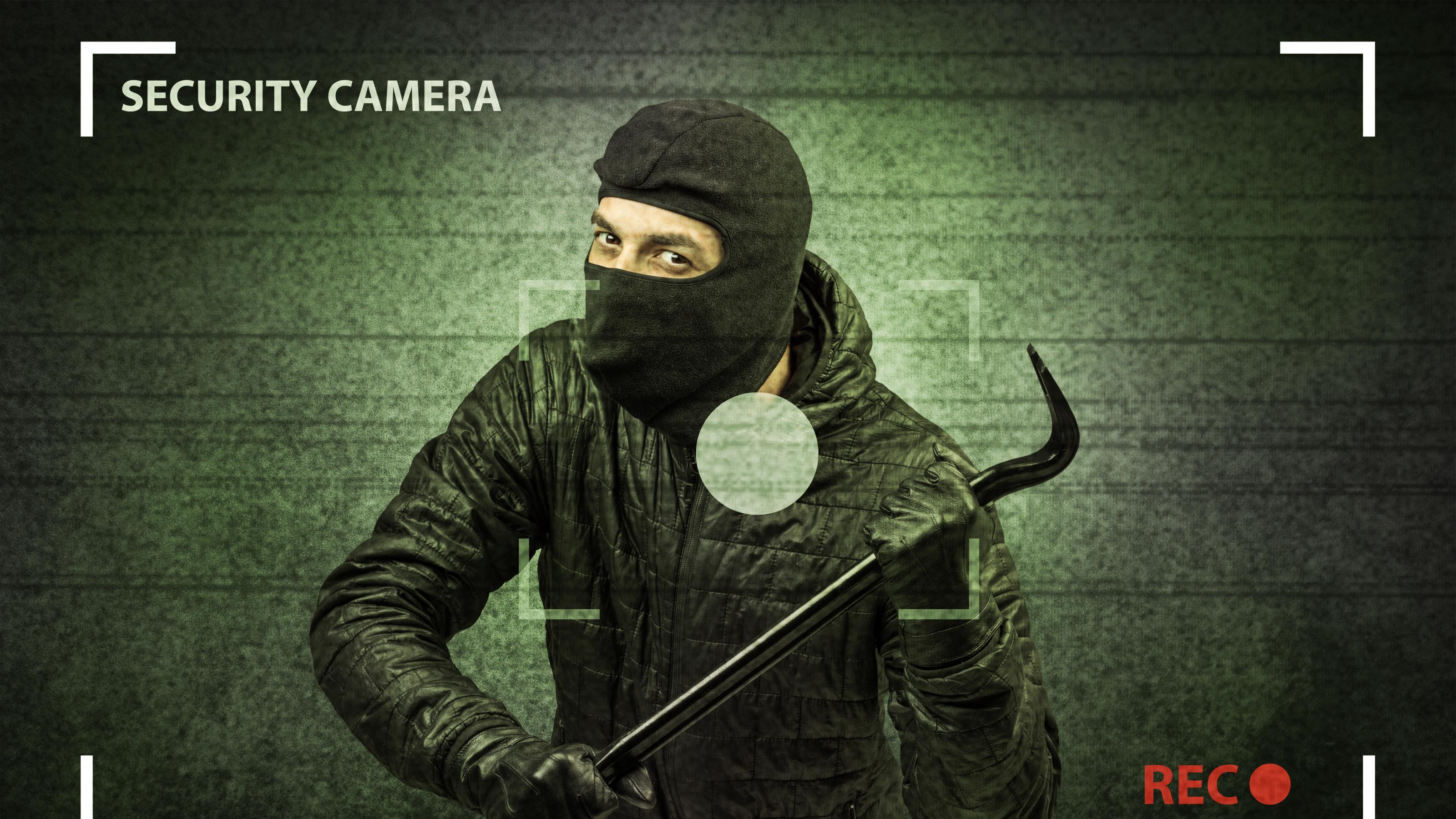 Kamera-Bild zeigt maskierten Einbrecher mit Brecheisen
