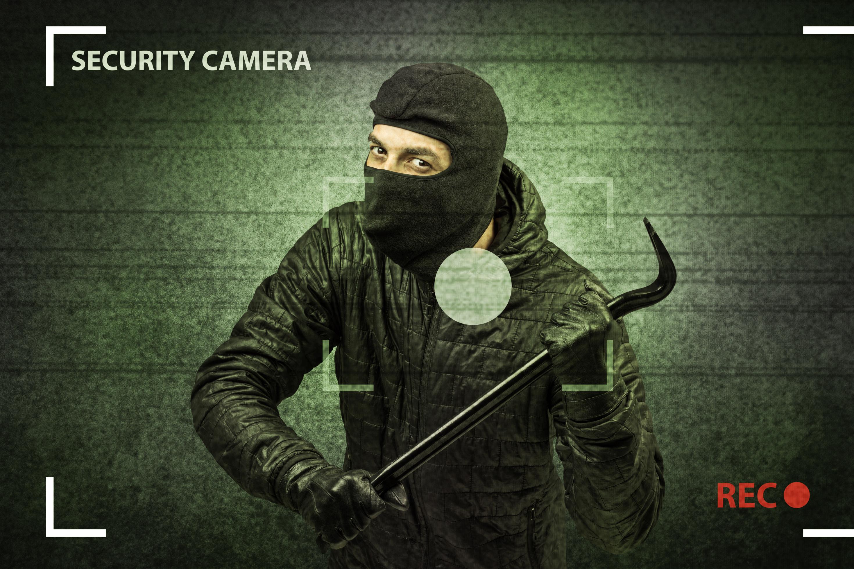 Kamera-Bild zeigt maskierten Einbrecher mit Brecheisen