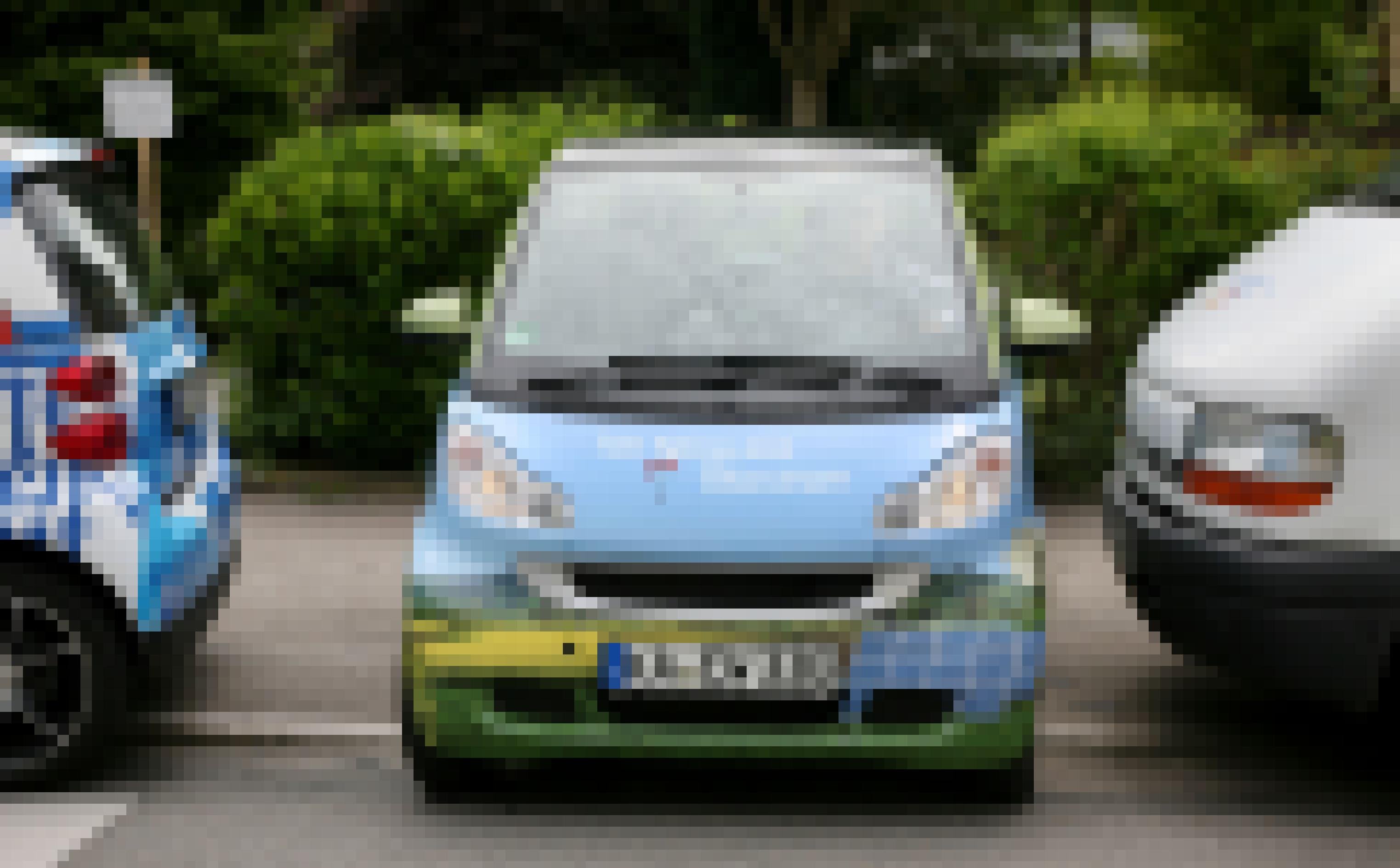 Ein elektrischer Smart parkt quer zwischen zwei Autos.