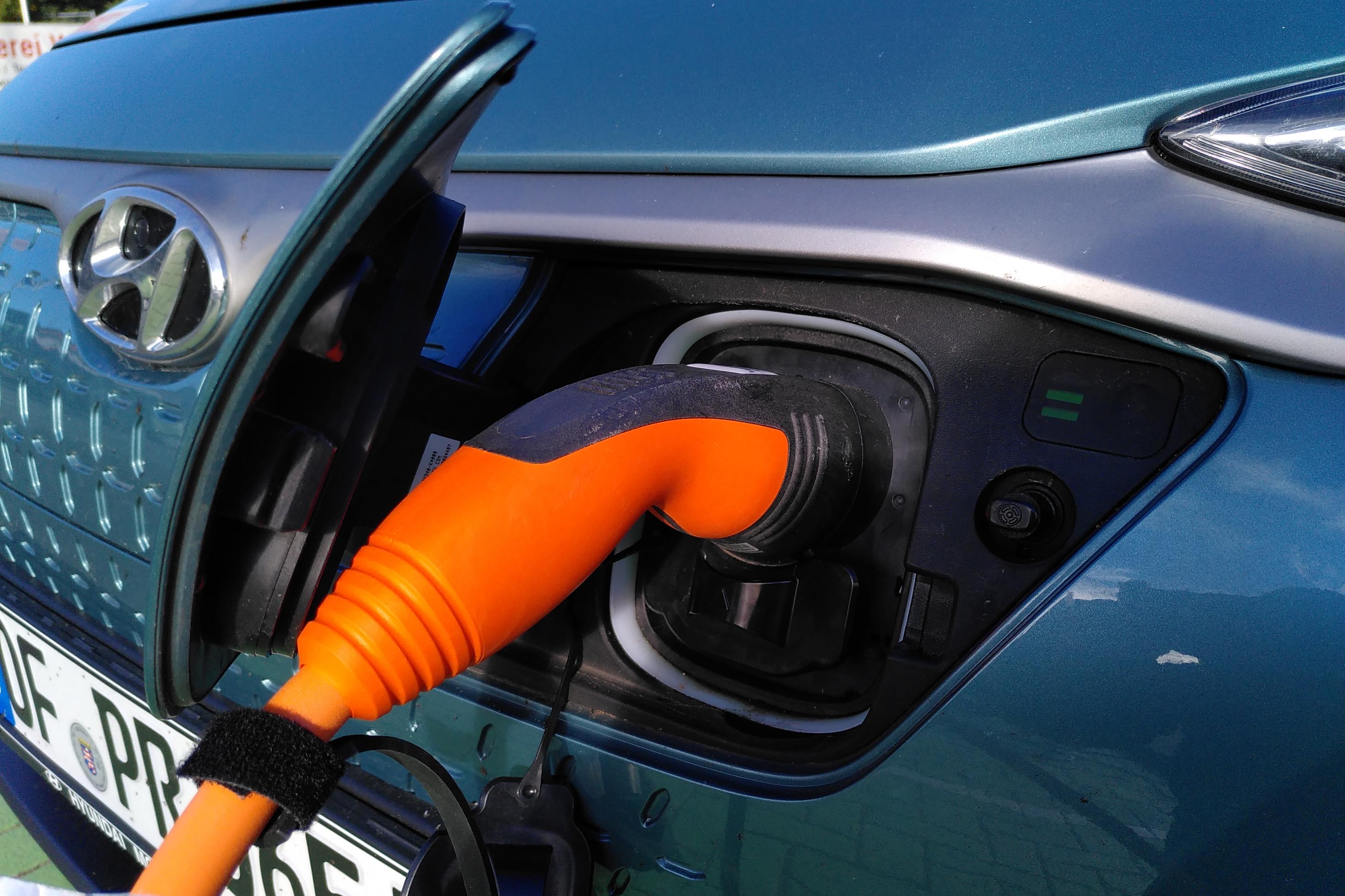 Ein Ladekabel steckt in einem Elektroauto