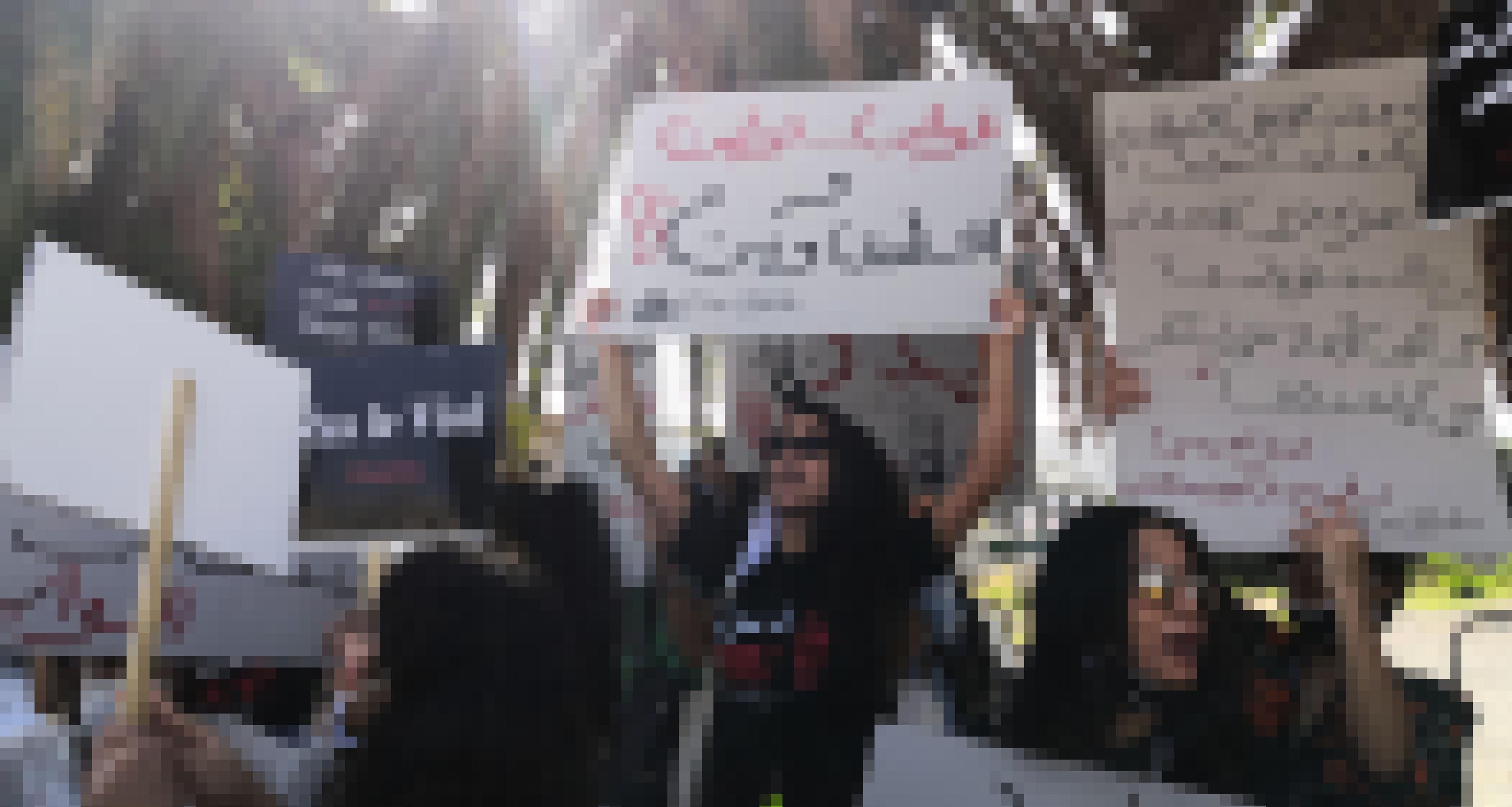 Protest von Frauen mit Schildern auf Arabisch, Englisch und Französisch
