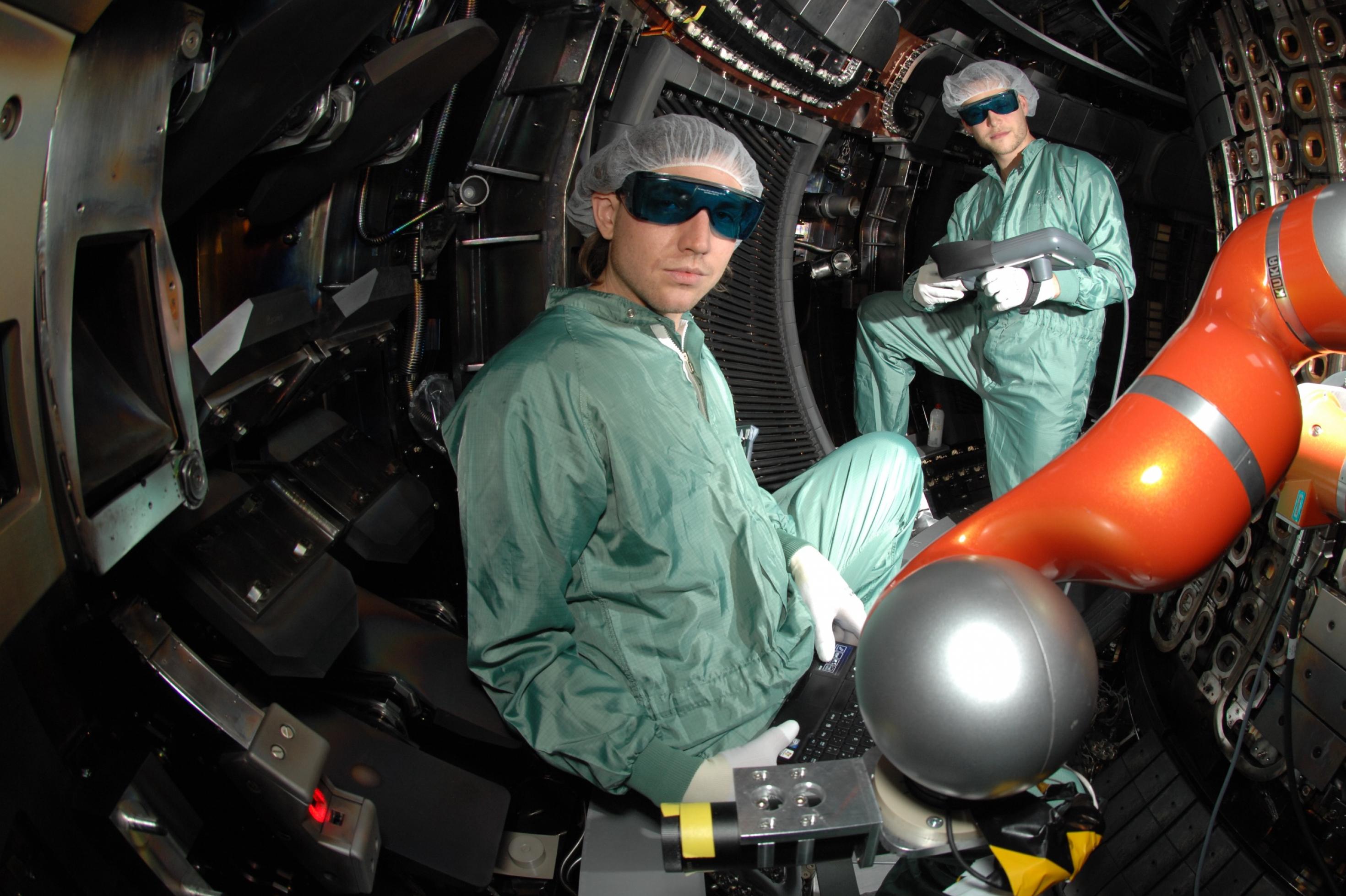Forscher mit Arbeitsbrillen in einer Fusionsreaktorkammer