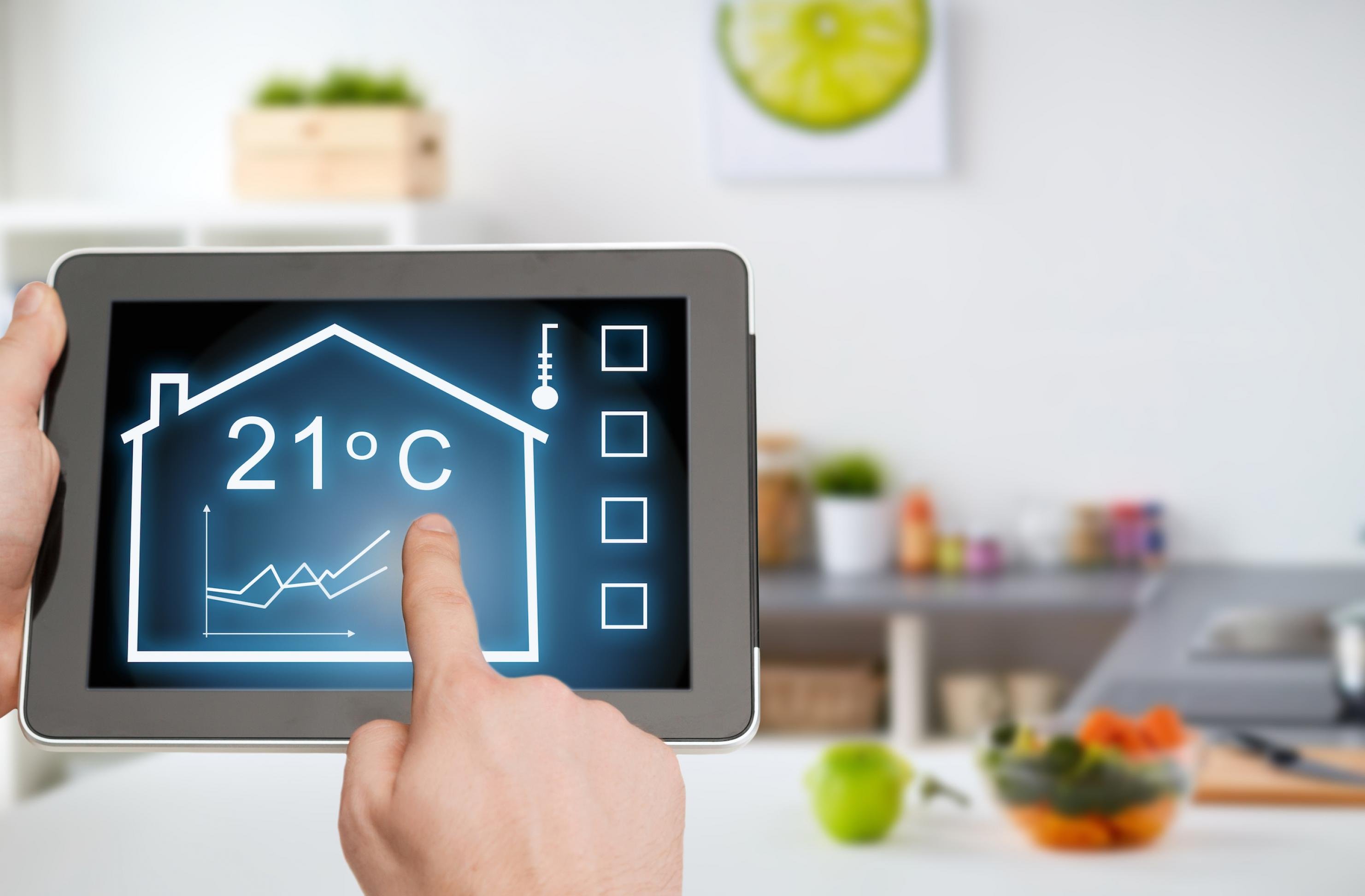 Ein Tablet mit einem Haus, einer Temperaturanzeige und einem Regler als Symbol für digitale Energie-Apps.