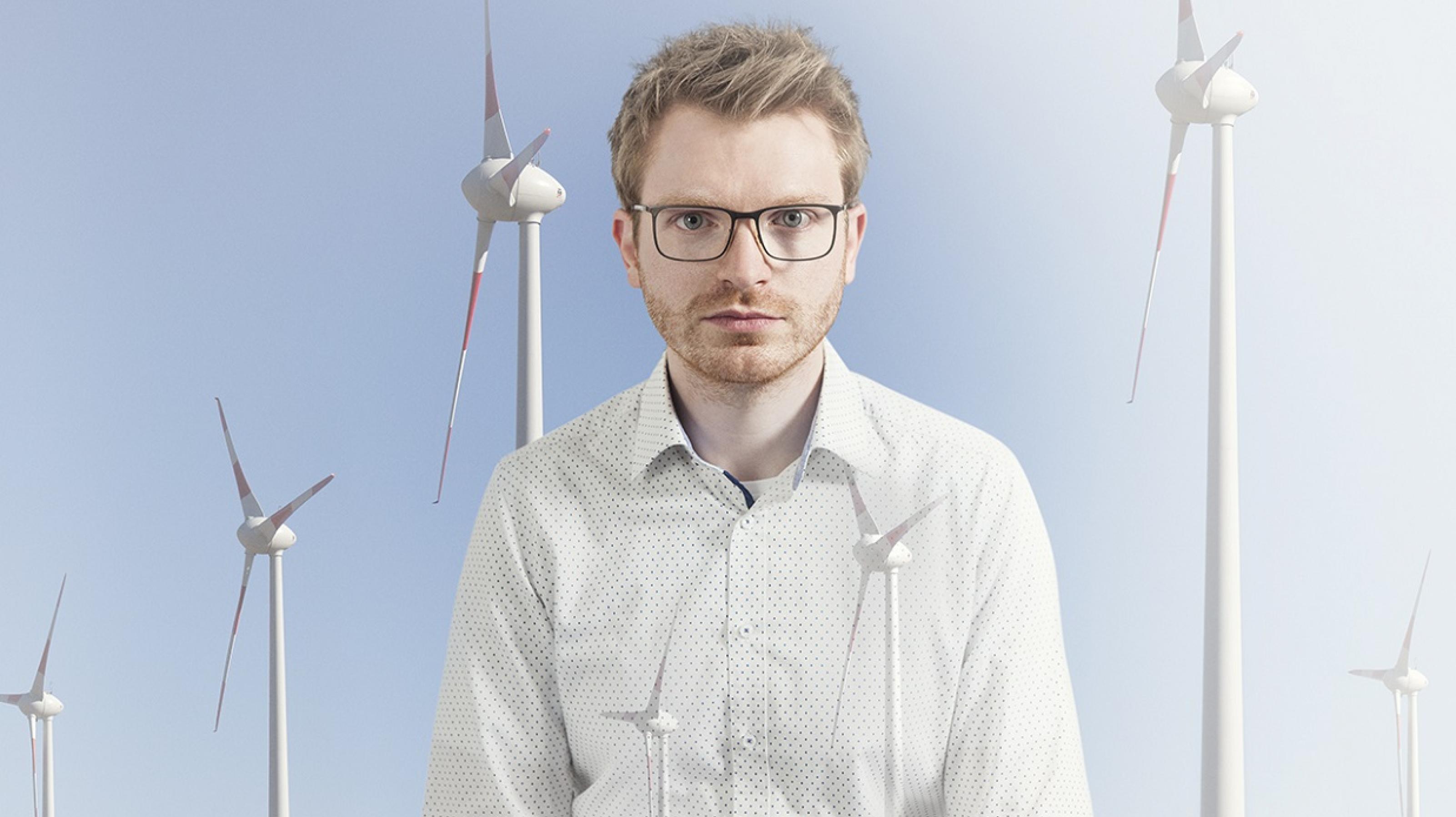Das Bild aus dem Fotoband „Alltagswelten des Klimawandels“ zeigt einen jungen Mann vor drei Windrädern.