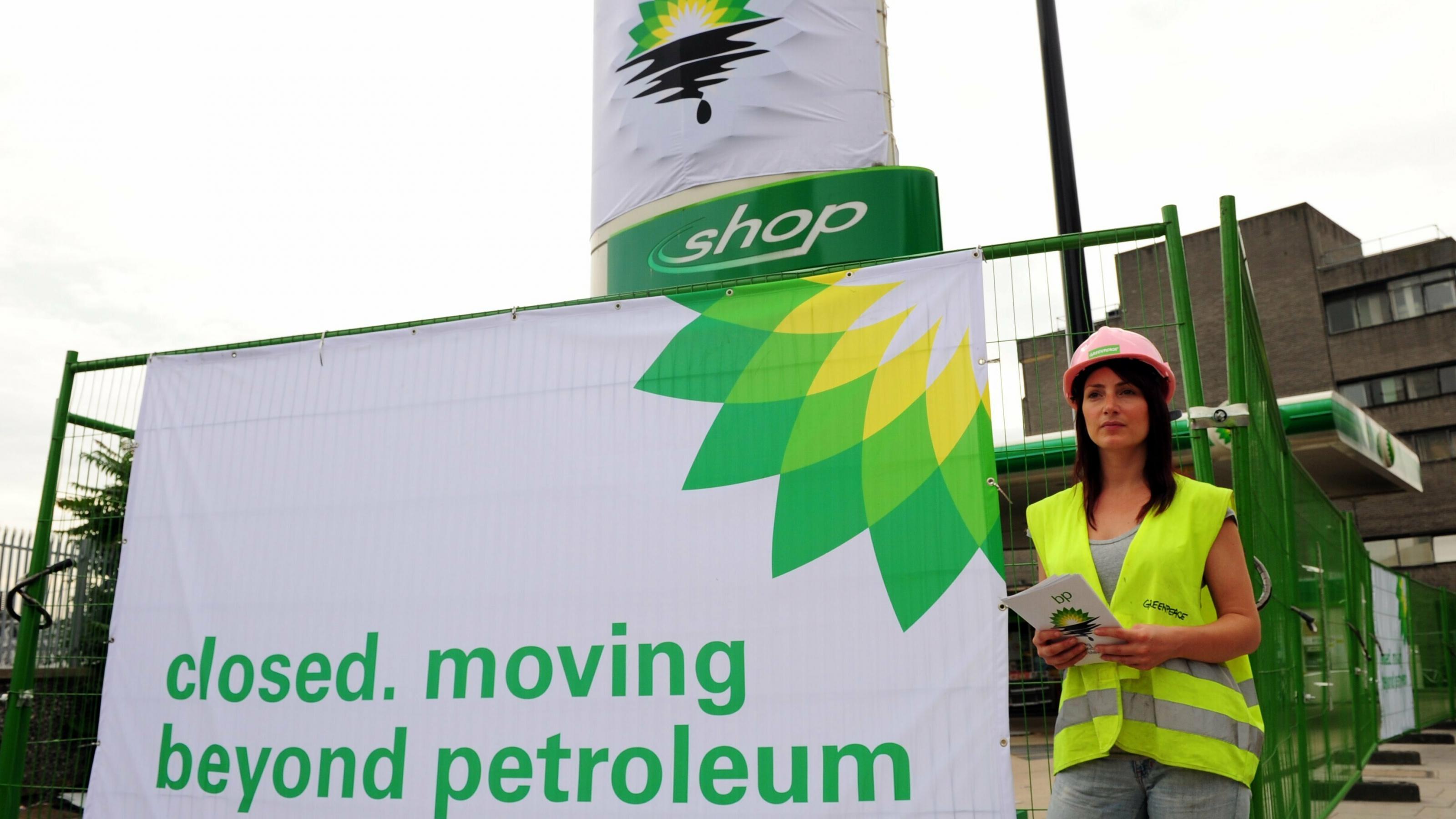 Eine Greenpeace-Aktivistin steht am 27. Juli 2010 in Camden, London, Großbritannien, vor einer BP-Tankstelle, die wegen einer Protestaktion geschlossen wurde. Greenpeace-Aktivisten hatten nach eigenen Angaben alle BP-Tankstellen in London geschlossen und Schilder mit der Aufschrift: „Geschlossen. Weg vom Erdöl“. BP hatte bestätigt, dass Tony Hayward zurücktreten wird, nachdem das Unternehmen im zweiten Quartal des Jahres Verluste in Höhe von 11 Milliarden Pfund verzeichnet hat. Im Jahr zuvor hatte Hayward BPs neue Solarsparte geschlossen.