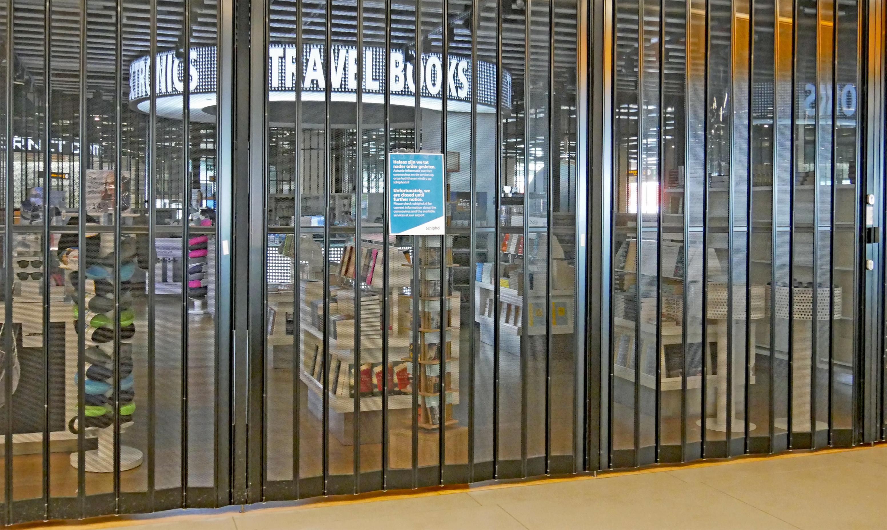 Die weiße Leuchtschrift „Travelbooks“ ist hinter einem geschlossenen Ladengitter zu sehen. Daran hängt ein Zettel, das Geschäft bleibe bis auf Weiteres geschlossen.  Wie viele andere hat auch dieser Buchladen auf dem Flughafen Amsterdam keine Kunden und damit keine Umsätze. Mieten und sonstige Kosten laufen aber weiter. Diese Probleme versuchen Konjunkturprogramme in vielen Staaten abzumildern.