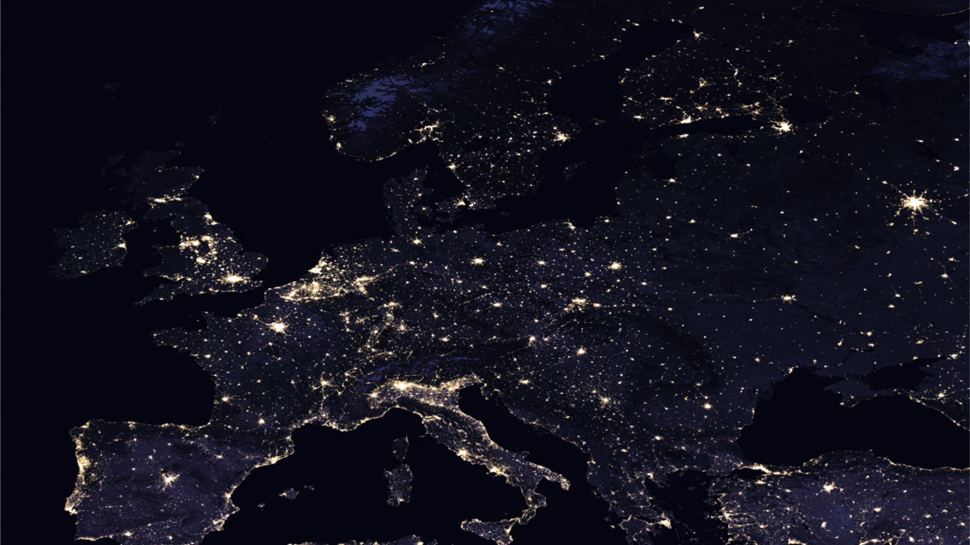 Europa von oben, aufgenommen bei Nacht. Man sieht Lichter, die leuchten.