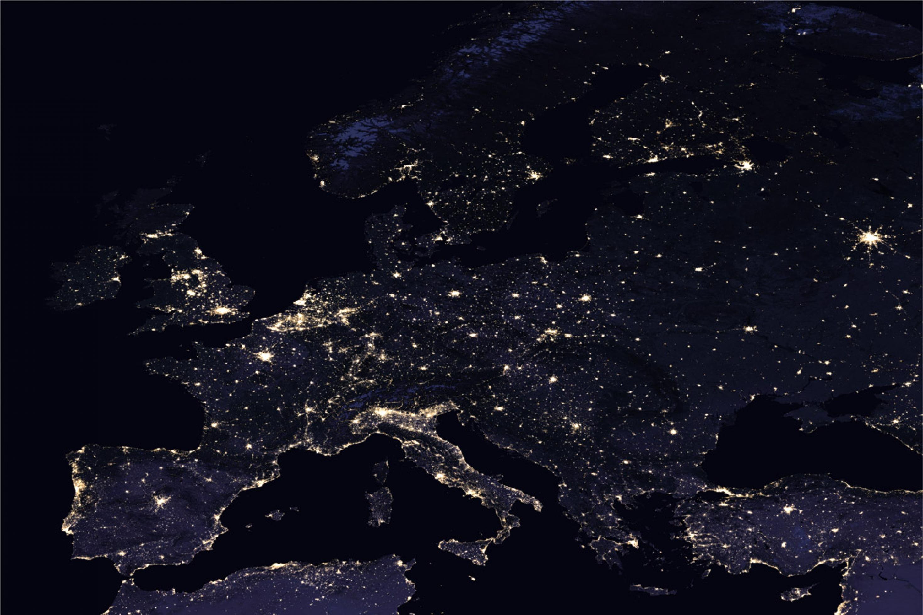 Europa von oben, aufgenommen bei Nacht. Man sieht Lichter, die leuchten.