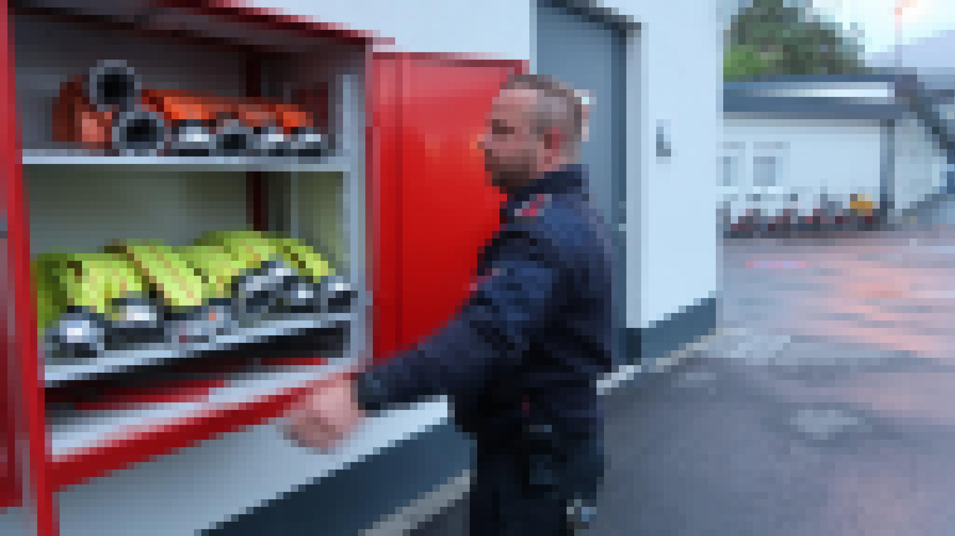 Feuerwehrmann Jürgen Scherzinger öffnet einen Schrank mit Schläuchen.