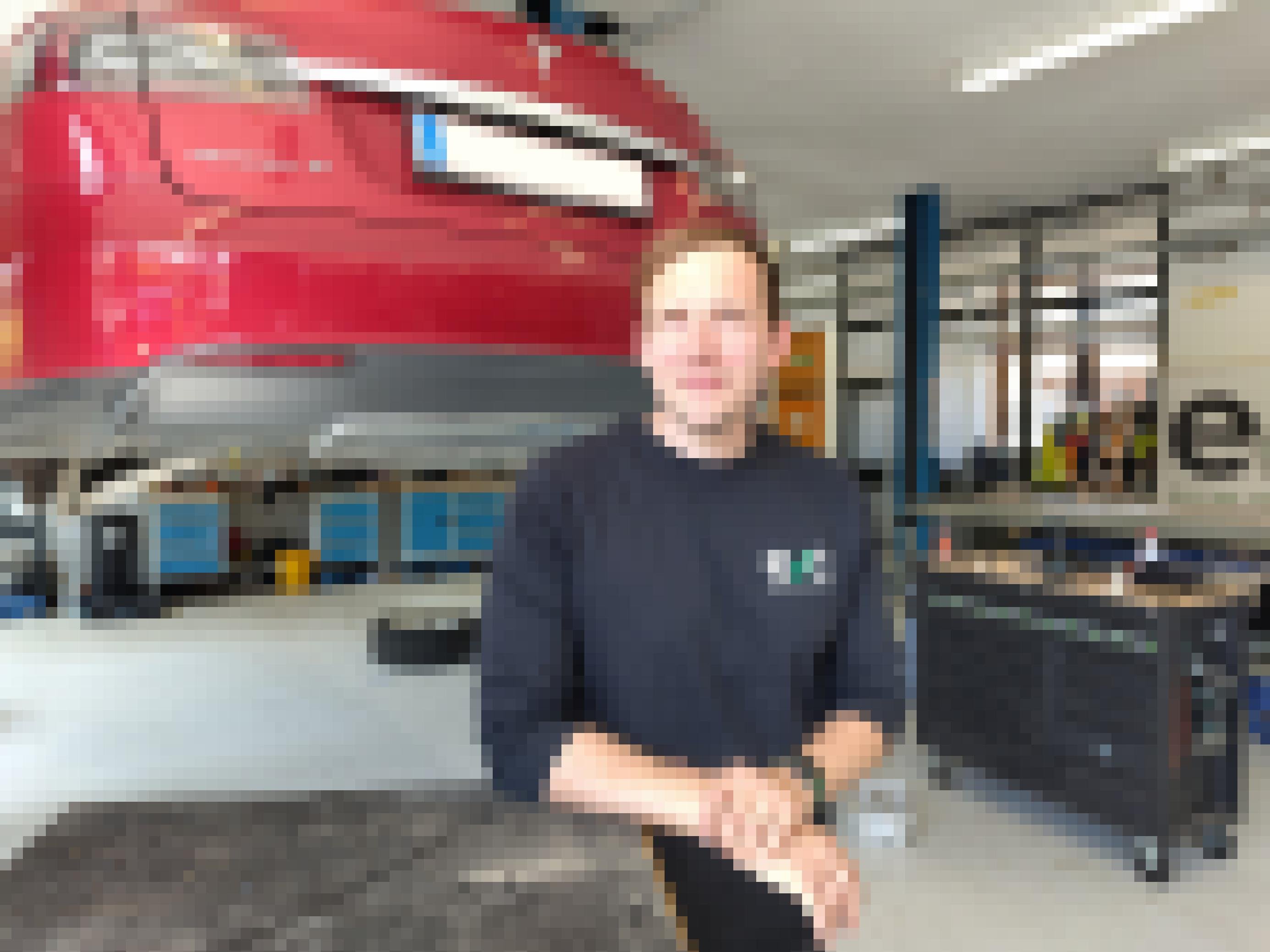 Otto Behrend steht vor einem aufgebockten Tesla Model S.