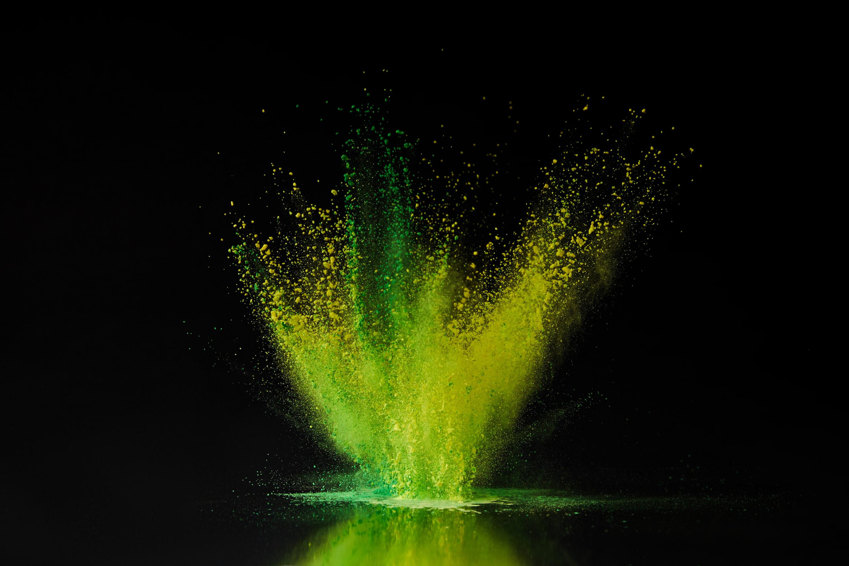 Fotomontage einer Wasseroberfläche, aus der grüne und gelbe Tropfen emporschießen