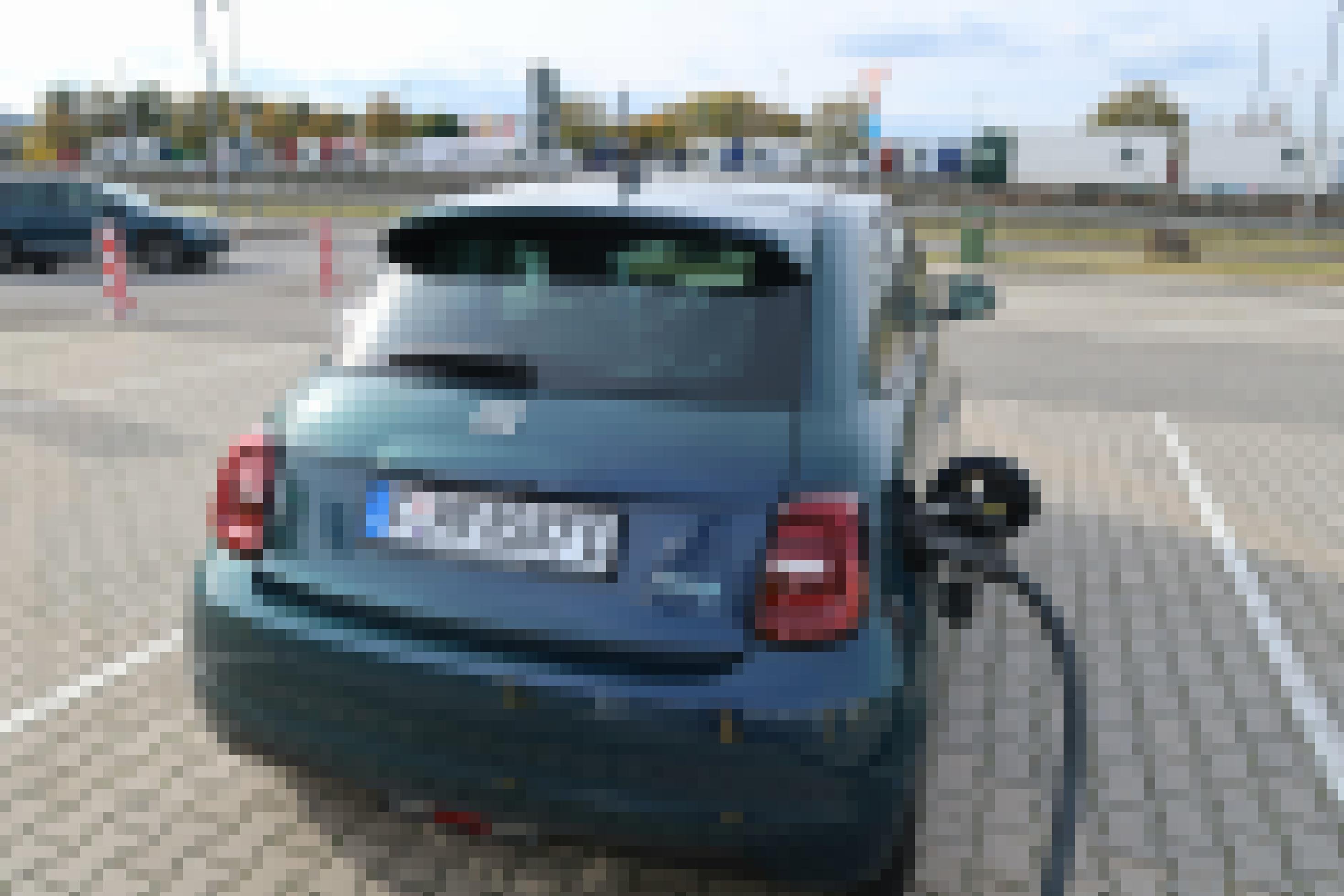 Ein kleines Elektroauto ist an eine Ladestation angeschlossen.