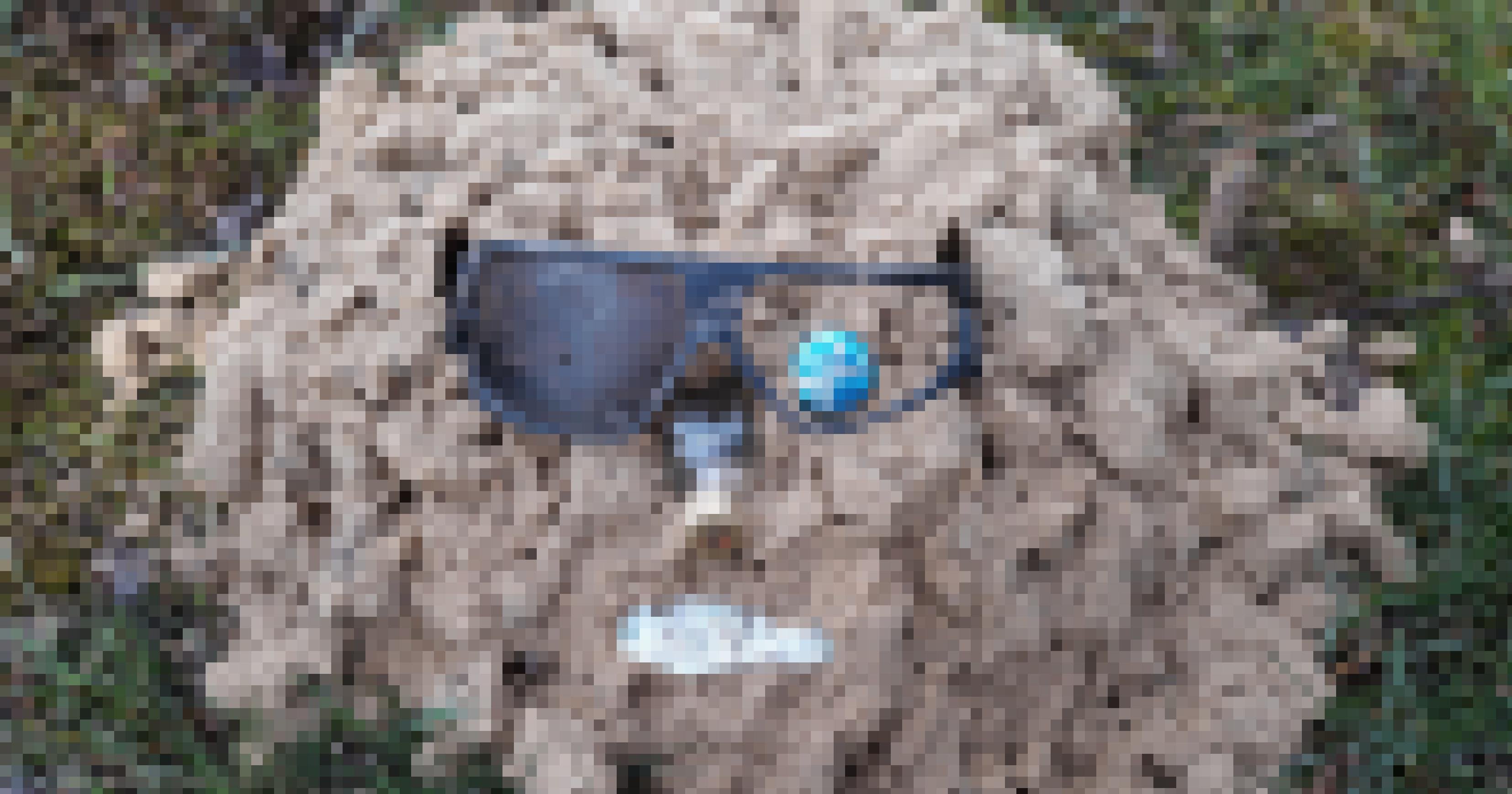 eine Sand mit Schutzbrille und einer Flasche darin [AI]