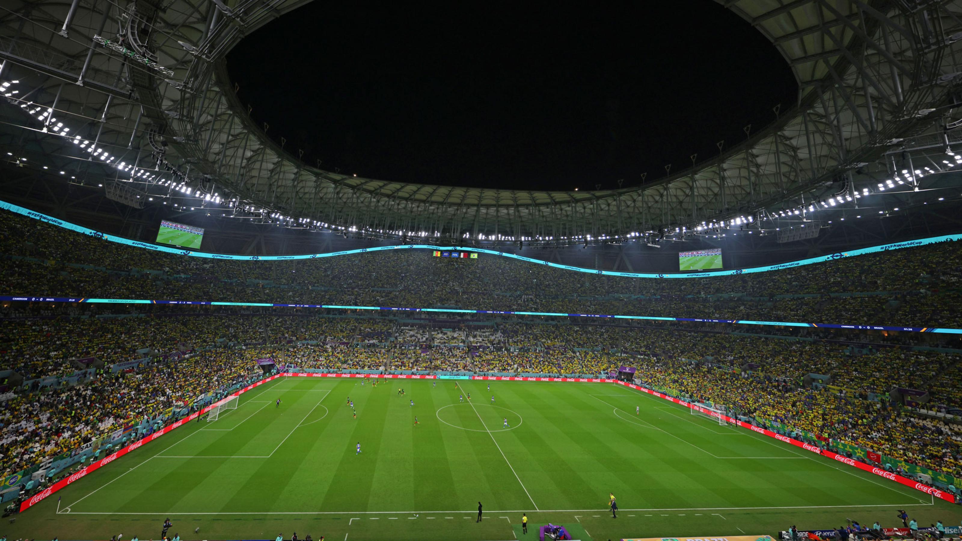 Das moderne Lusail-Stadion in Katar am Abend. Die Stadionränge sind gefüllt, auf dem Rasen sind Spieler zu erkennen.