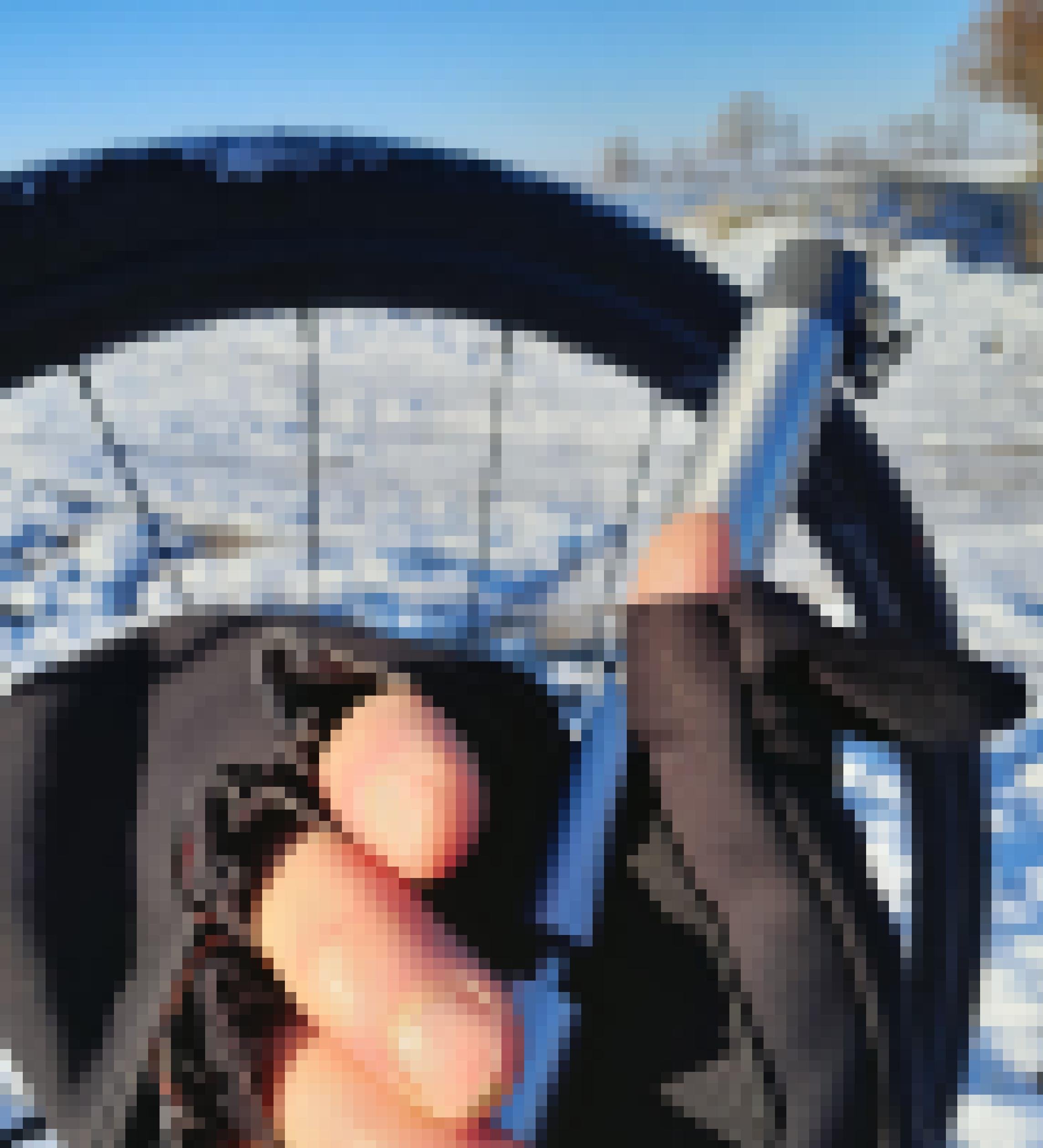 Vor einer Winterlichen Landschaftsszenerie mit dem Speichen eines Zweirads hält eine behandschuhte Hand eine kleine Notpumpe für Rennradreifen.