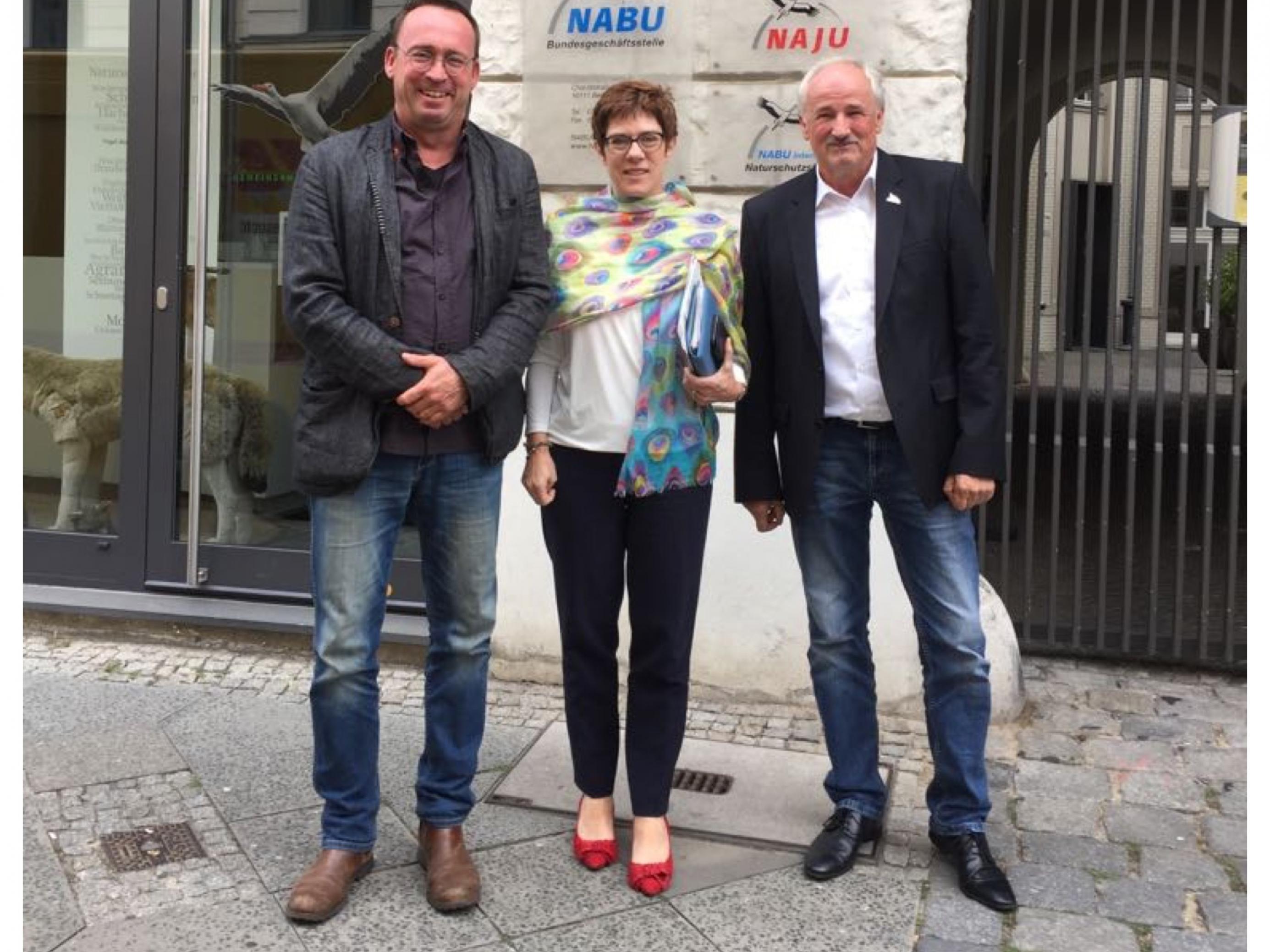 Drei Menschen vor einem Gebäudeeingang. Annegret Kramp-Karrenbauer in der Mitte. Links von ihr NABU-Bundesgeschäftsführer Leif Miller, rechts NABU-Präsident Olaf Tschimpke.