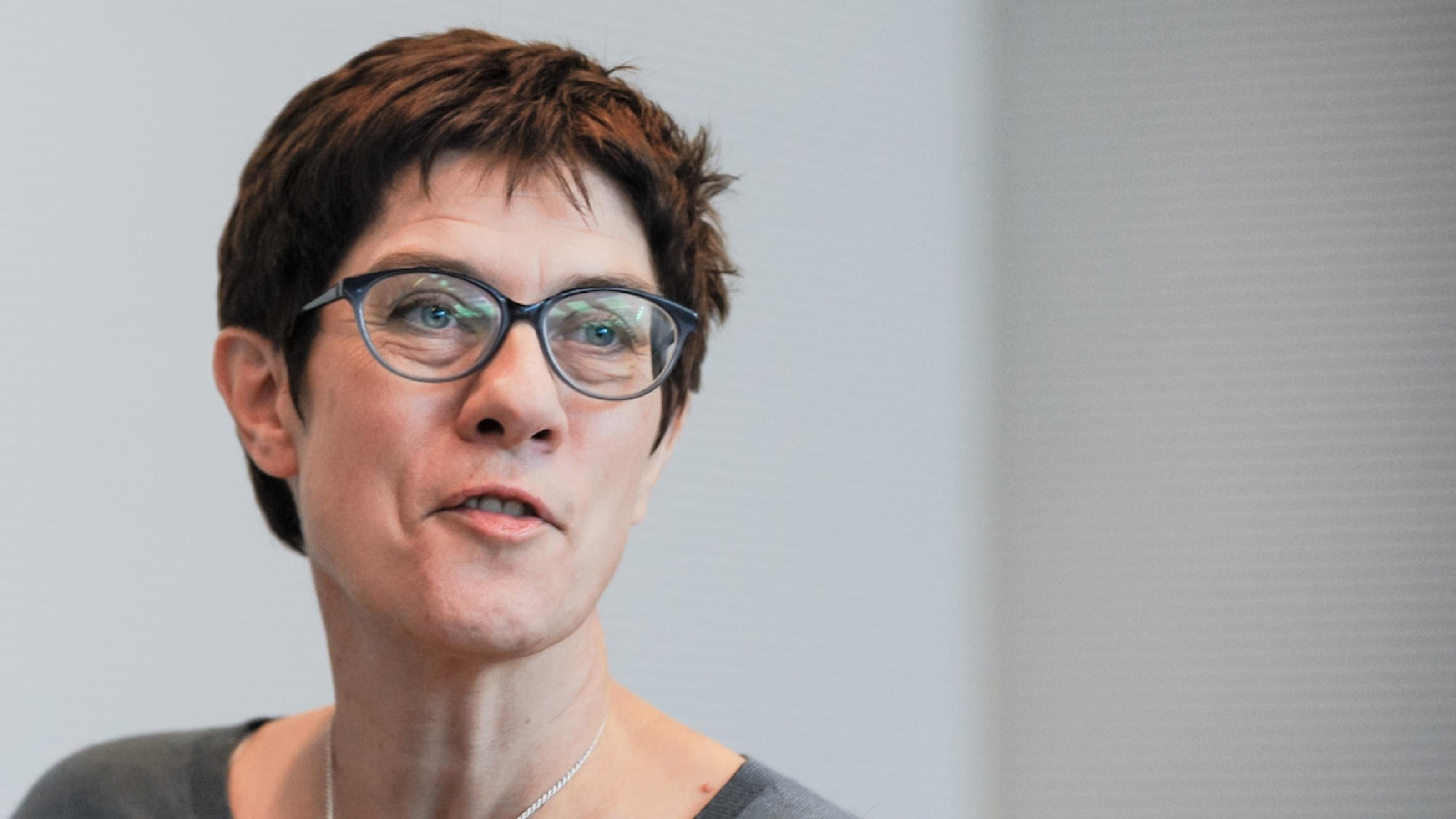 CDU-Vorsitzende Annegret Kramp-Karrenbauer. Eine Frau mit Brille und kurzen Haaren vor einer weißen Wand.