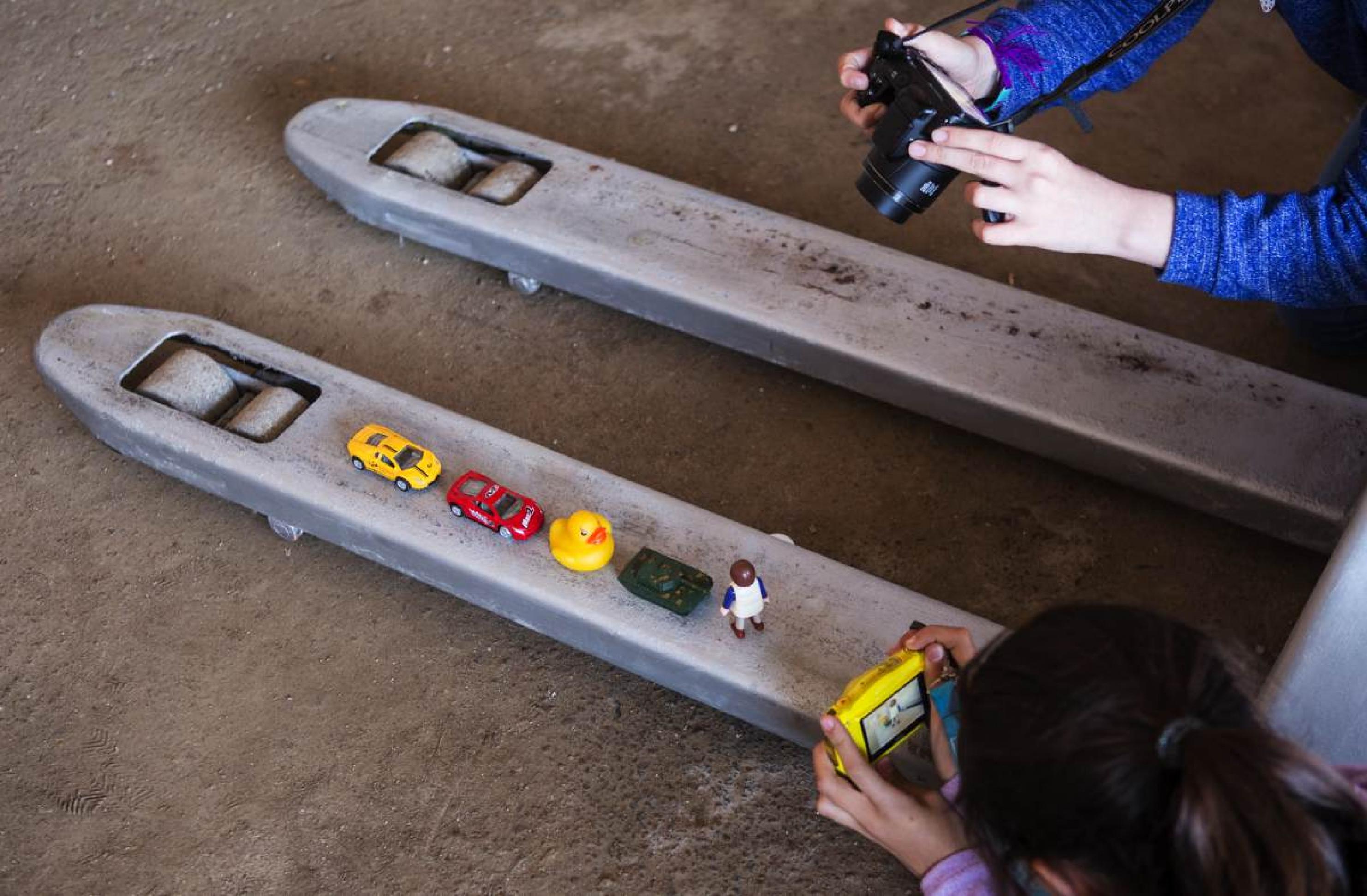 „Fotoethik – Der Workshop“. Spielerisch lernen Kinder den Umgang mit Bildern und Zeitgeschehen. Mit kleinen Figuren wird das Bild des Tank Man nachgestellt.