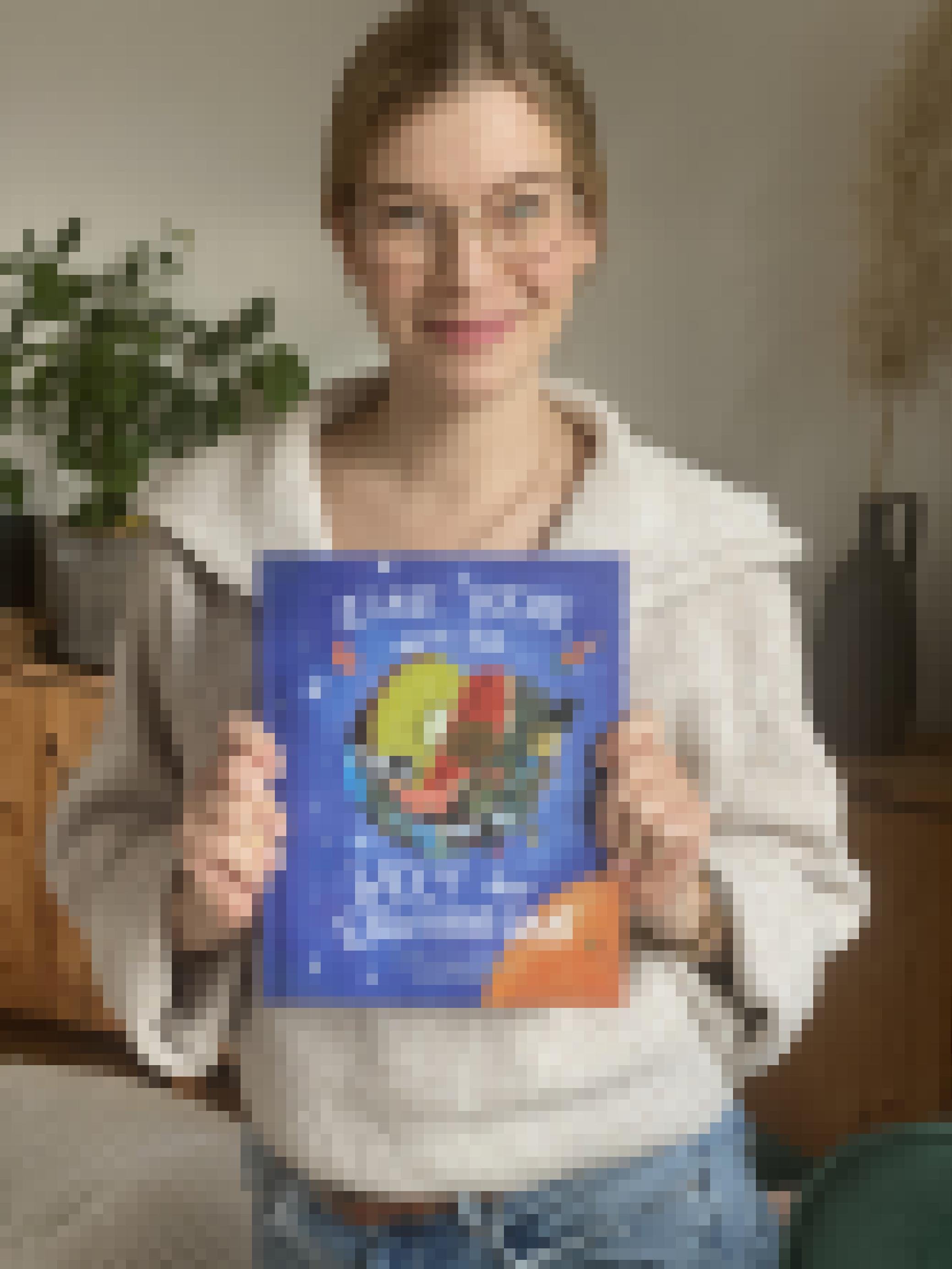 Die Autorin Franziska Delgas hält ihr Buch "Eine Reise durch die Welt der Ernährung" in den Händen