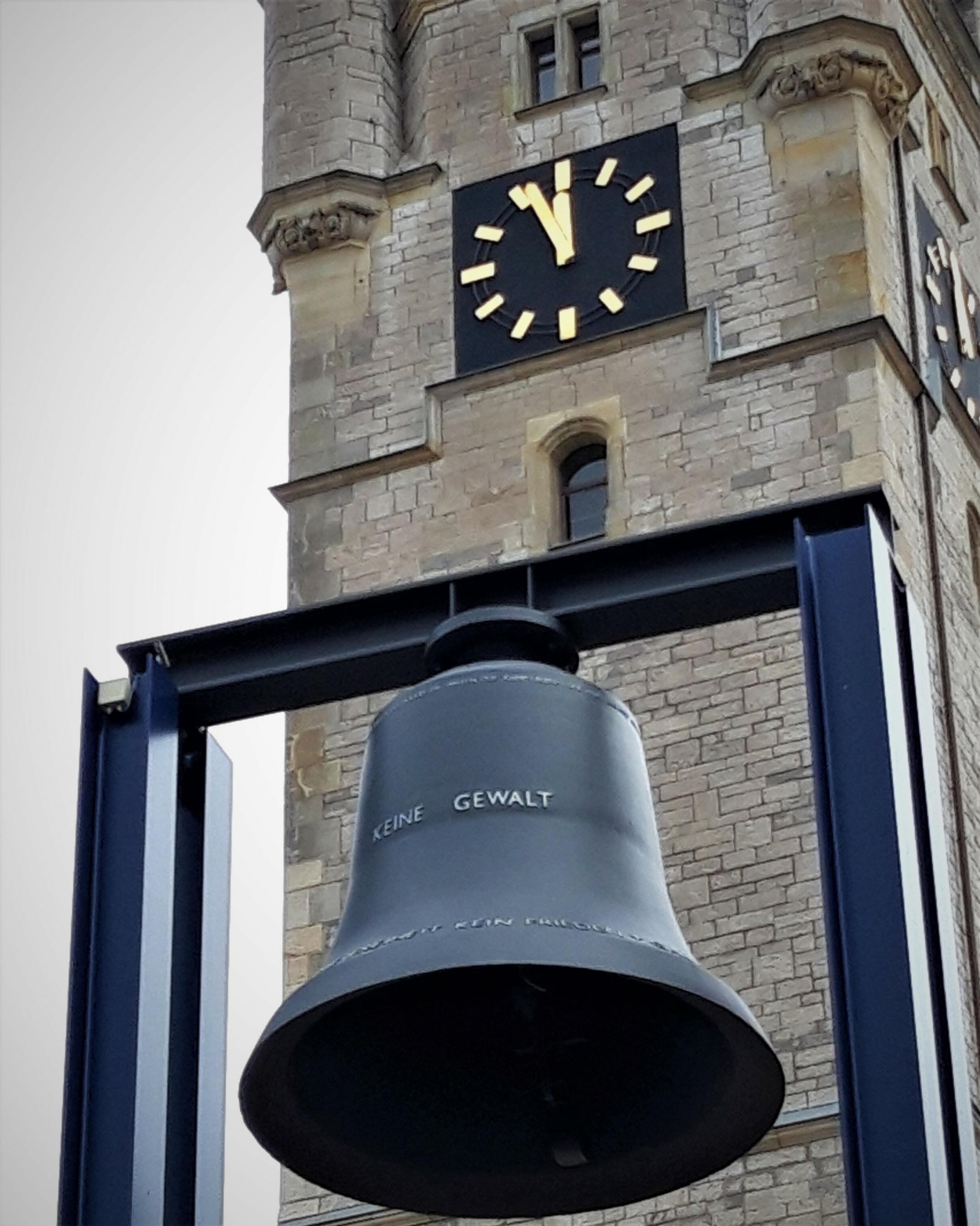 Auf der Glocke vor dem Rathausturm steht „keine Gewalt“. Die Tumuhr zeigt fünf vor Zwölf.
