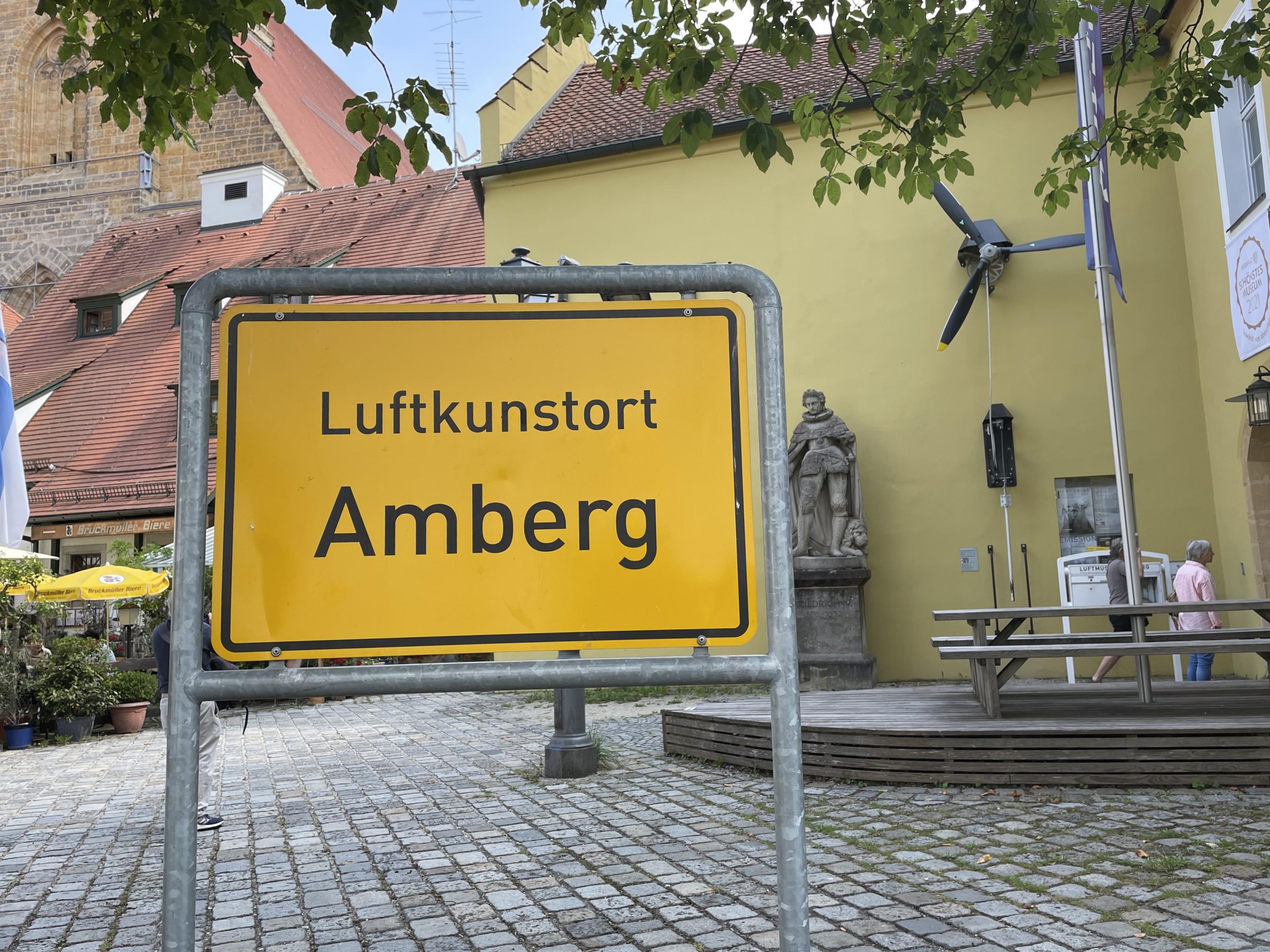 Ortsschild mit der Aufschrift „Luftkunstort Amberg“.