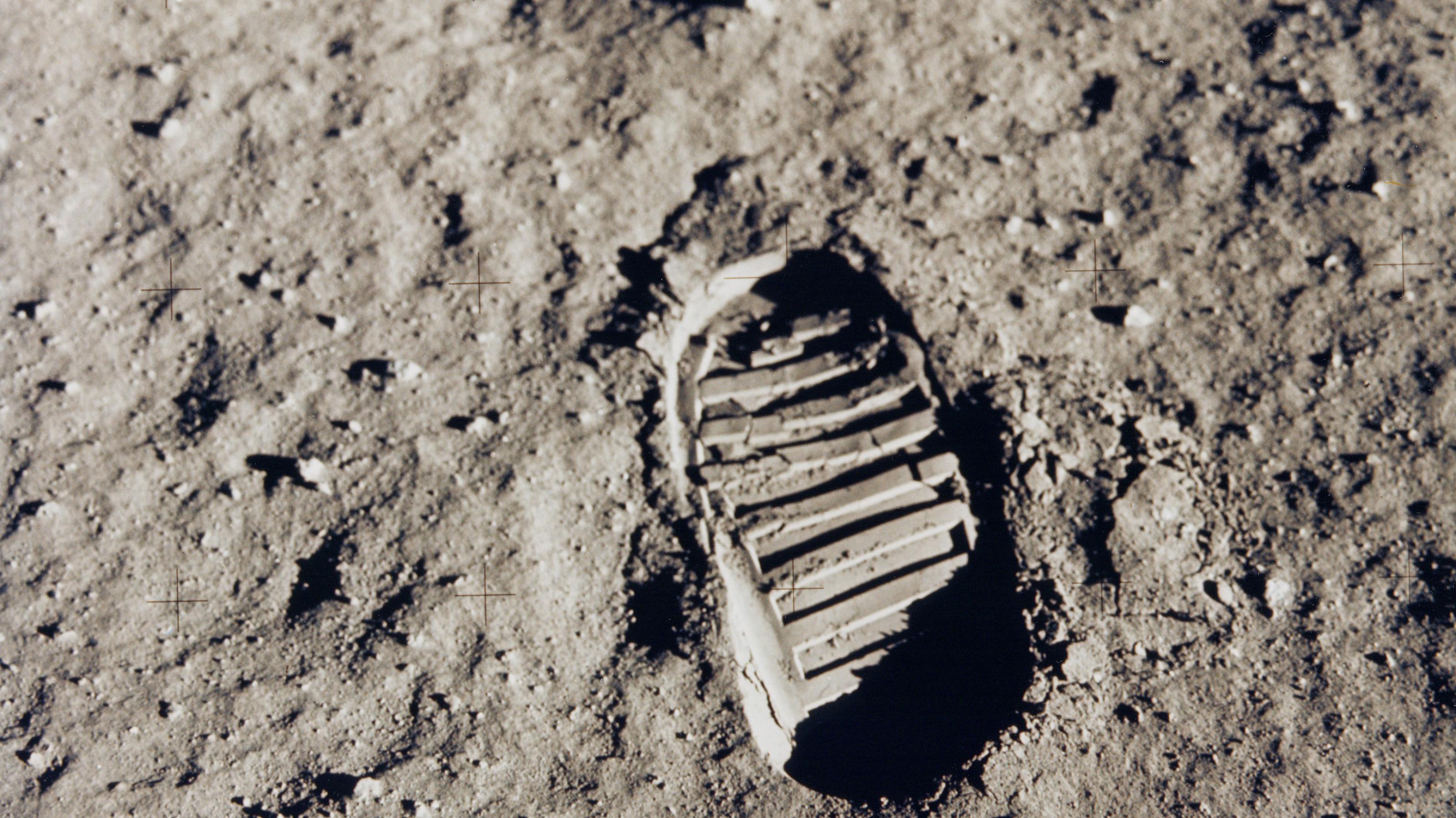 Fußabdruck im hellgrauen, puderigen Mondstaub, mit gut erkennbarem rillenförmigen Profil des Astronautenstiefels
