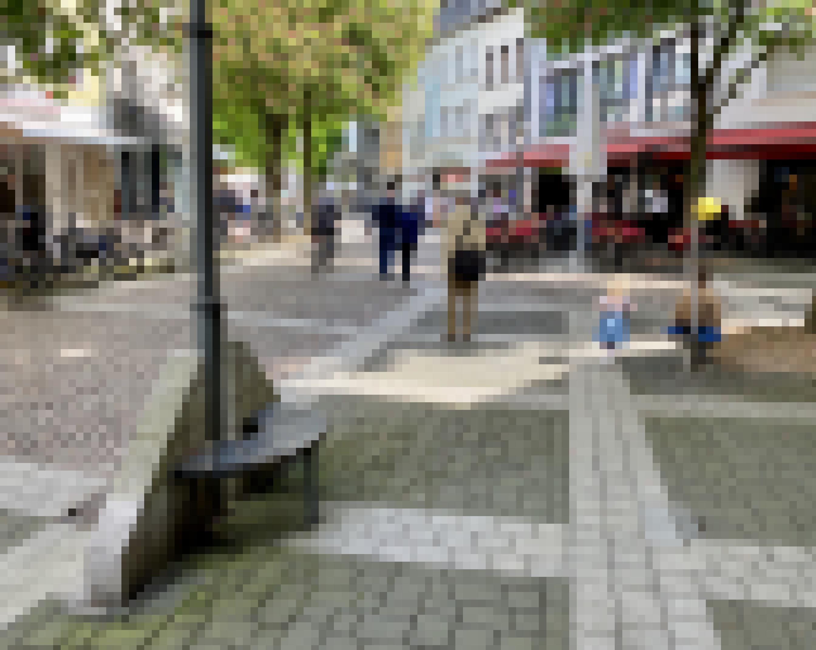 Kinder spielen an Geräten, Erwachsene fahren mit dem Fahrrad durch die Fußgängerzone oder gehen zu Fuß